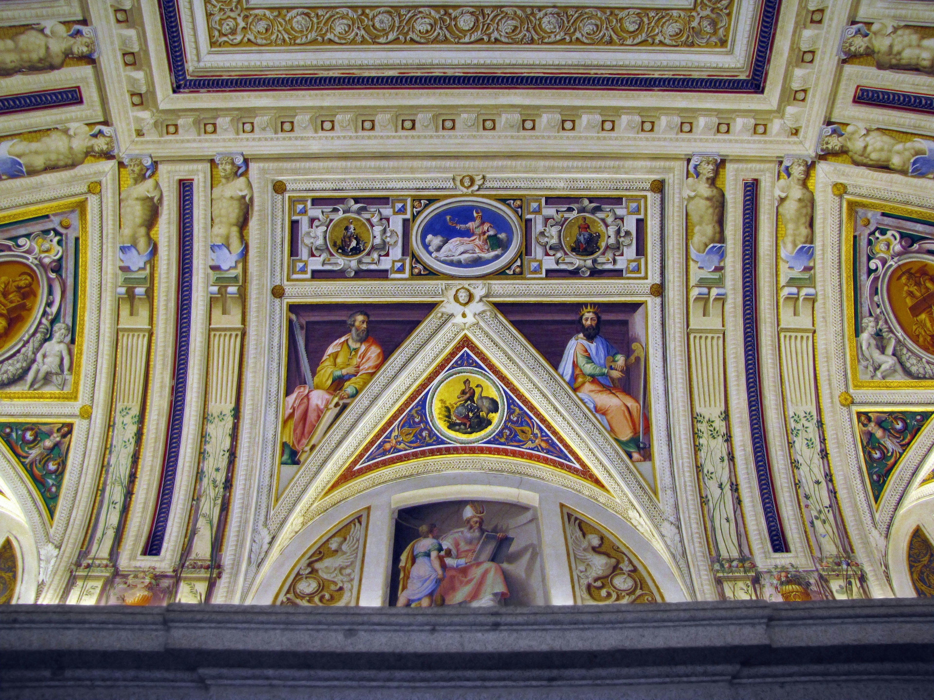 Elaborately decorated ceiling featuring paintings of saints and mythological symbols