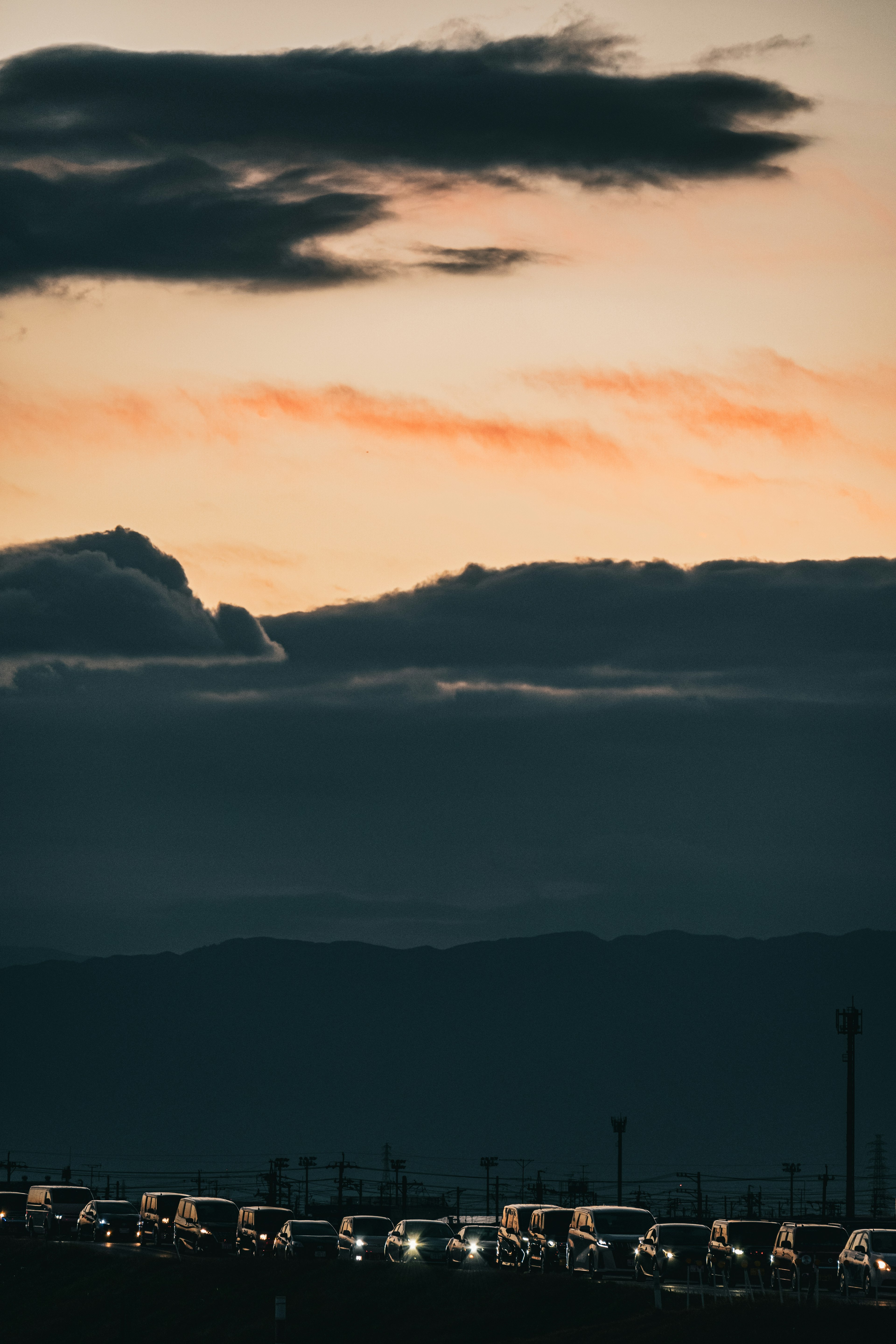 夕暮れ時の雲と車の列