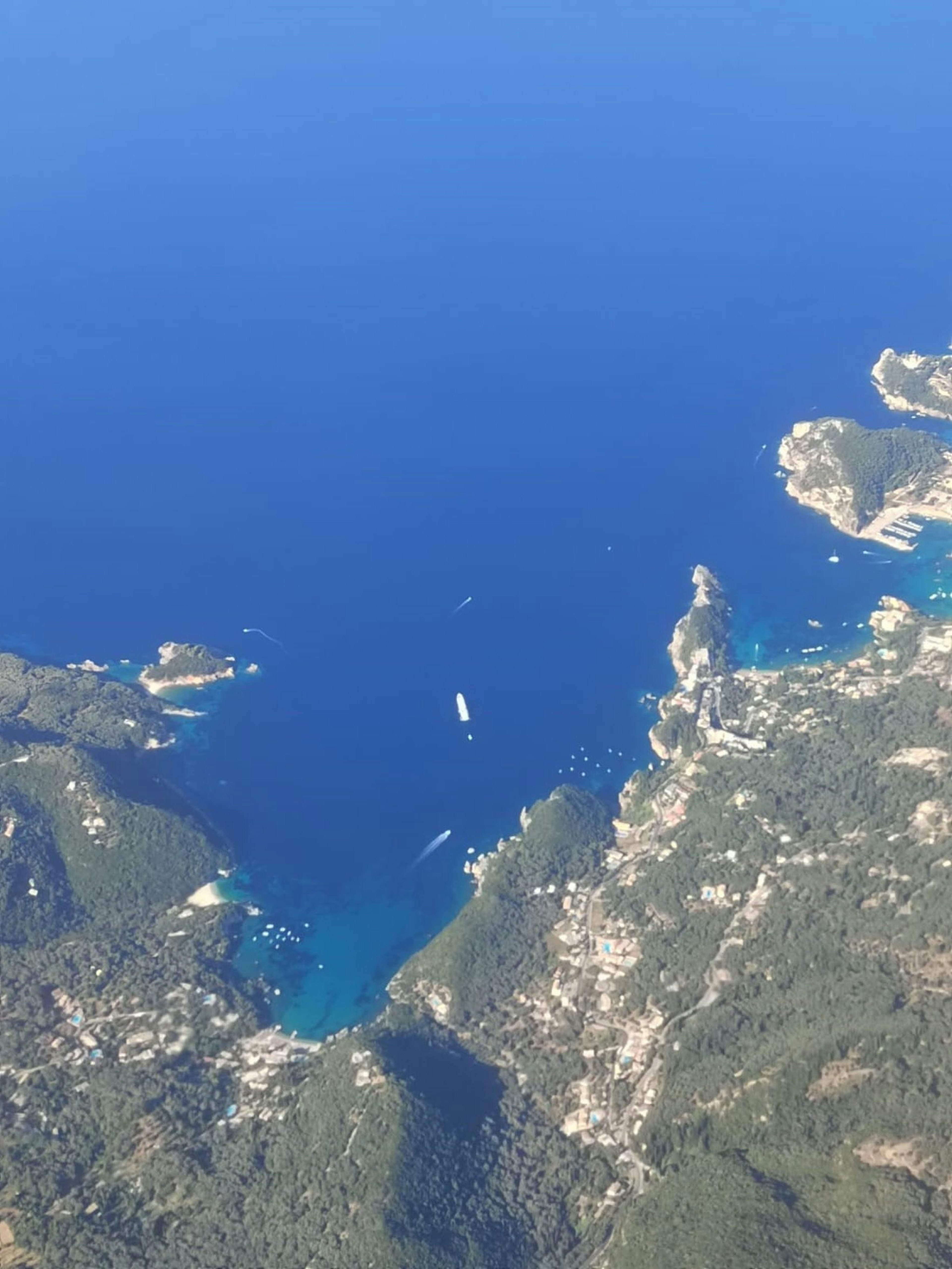 Vista aérea de un mar azul y islas con un barco flotando