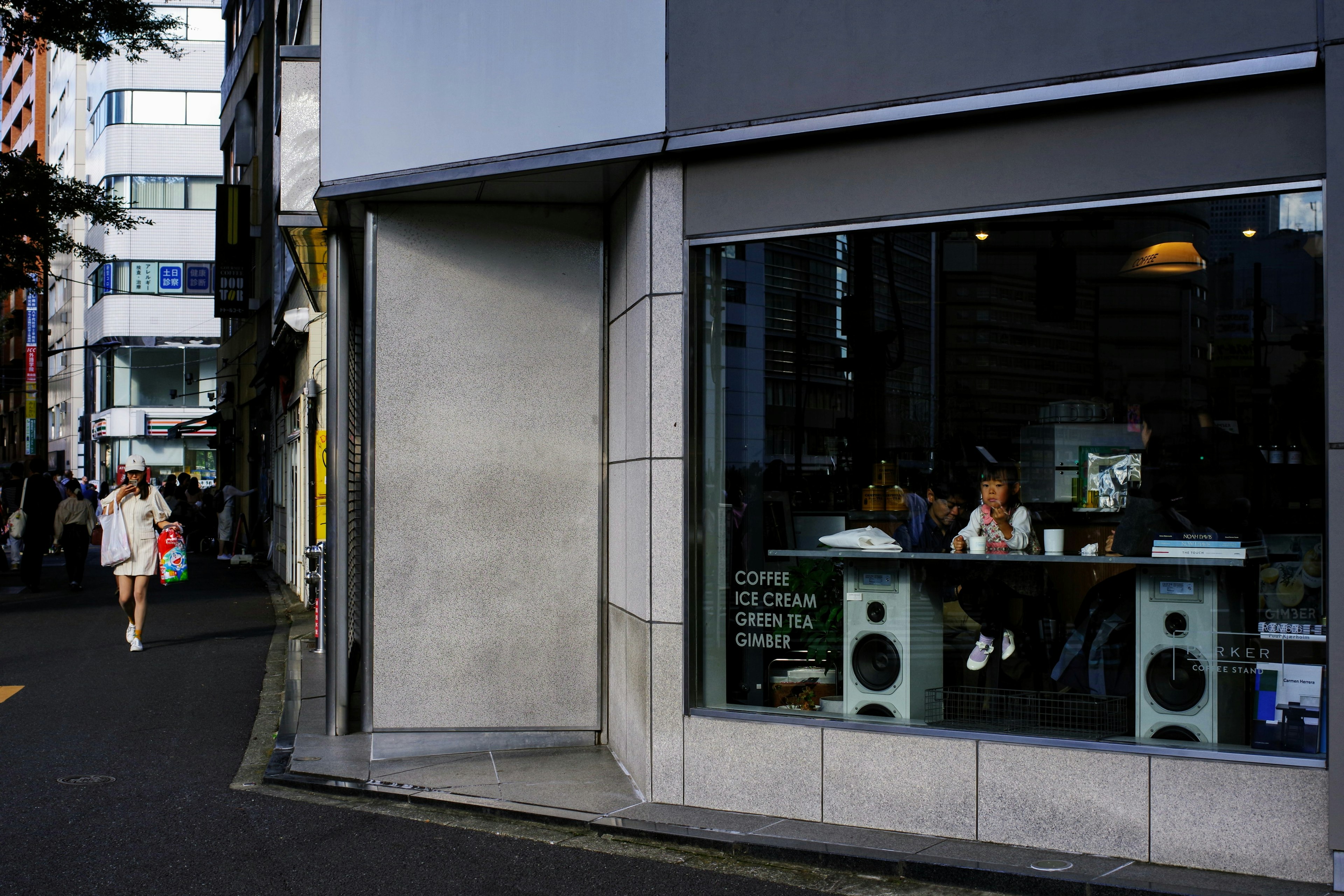 View of a café interior through a window with a person walking by