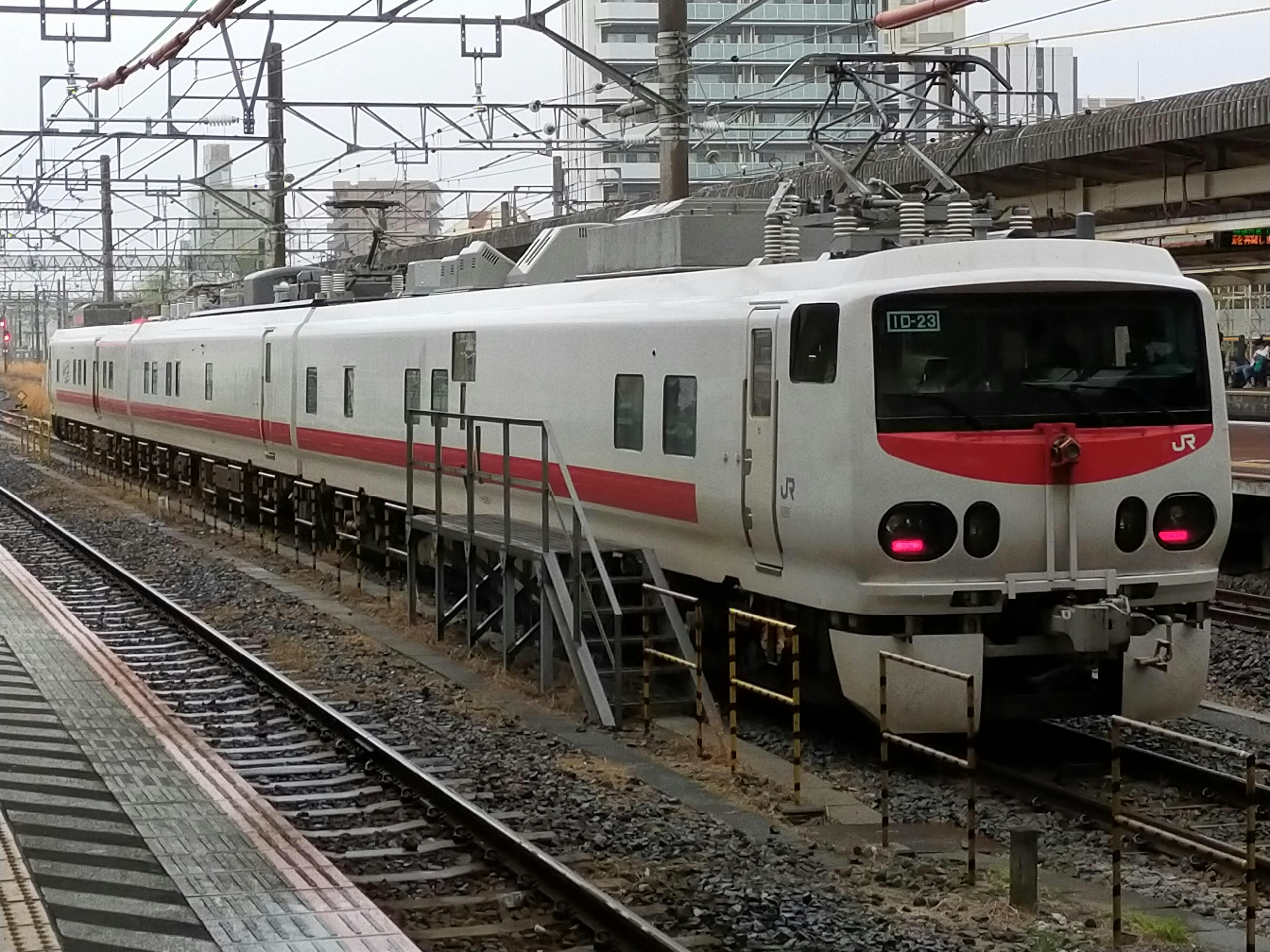 Tren blanco con franjas rojas estacionado en la estación