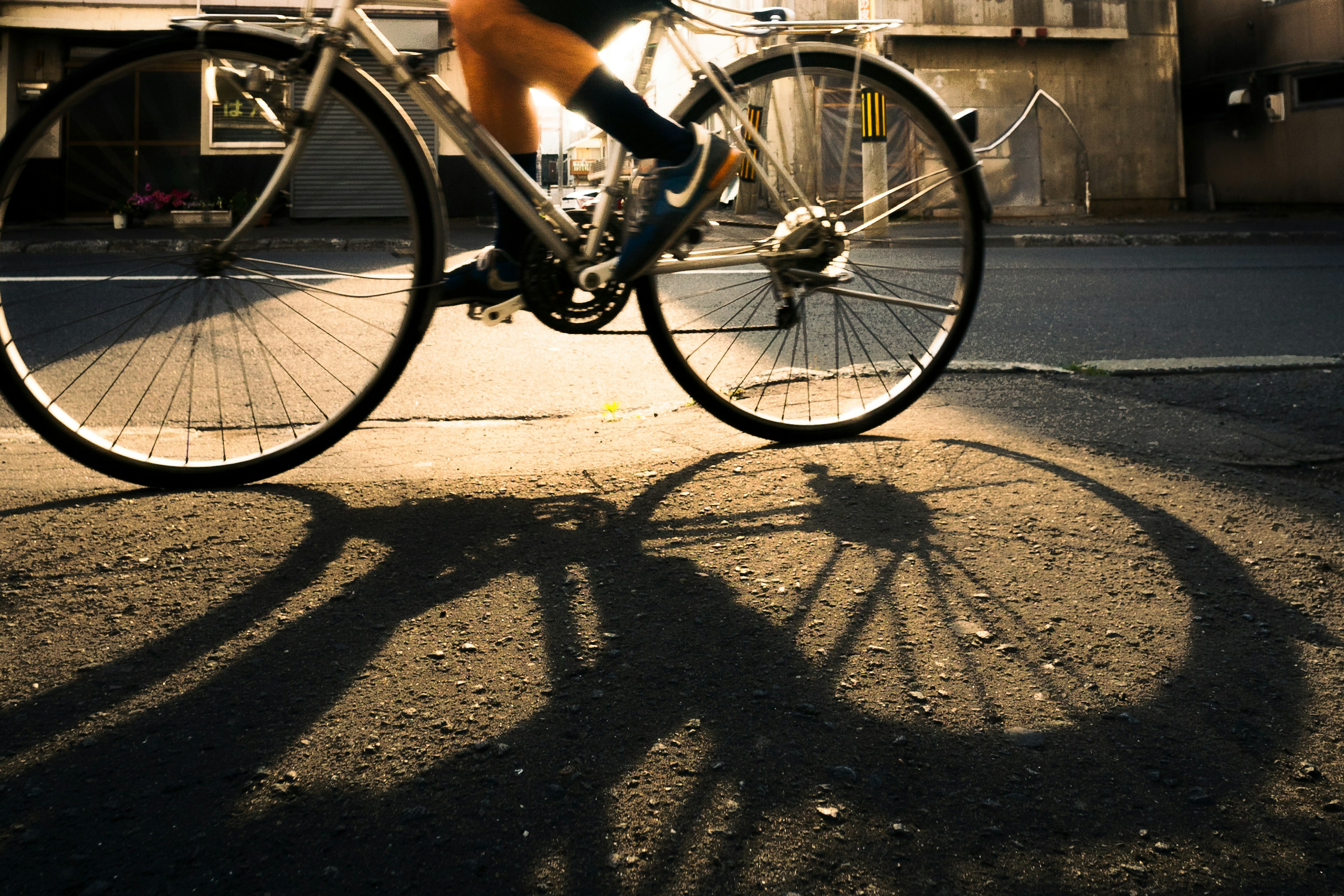 Schatten eines Fahrrads auf der Straße mit Sonnenlicht