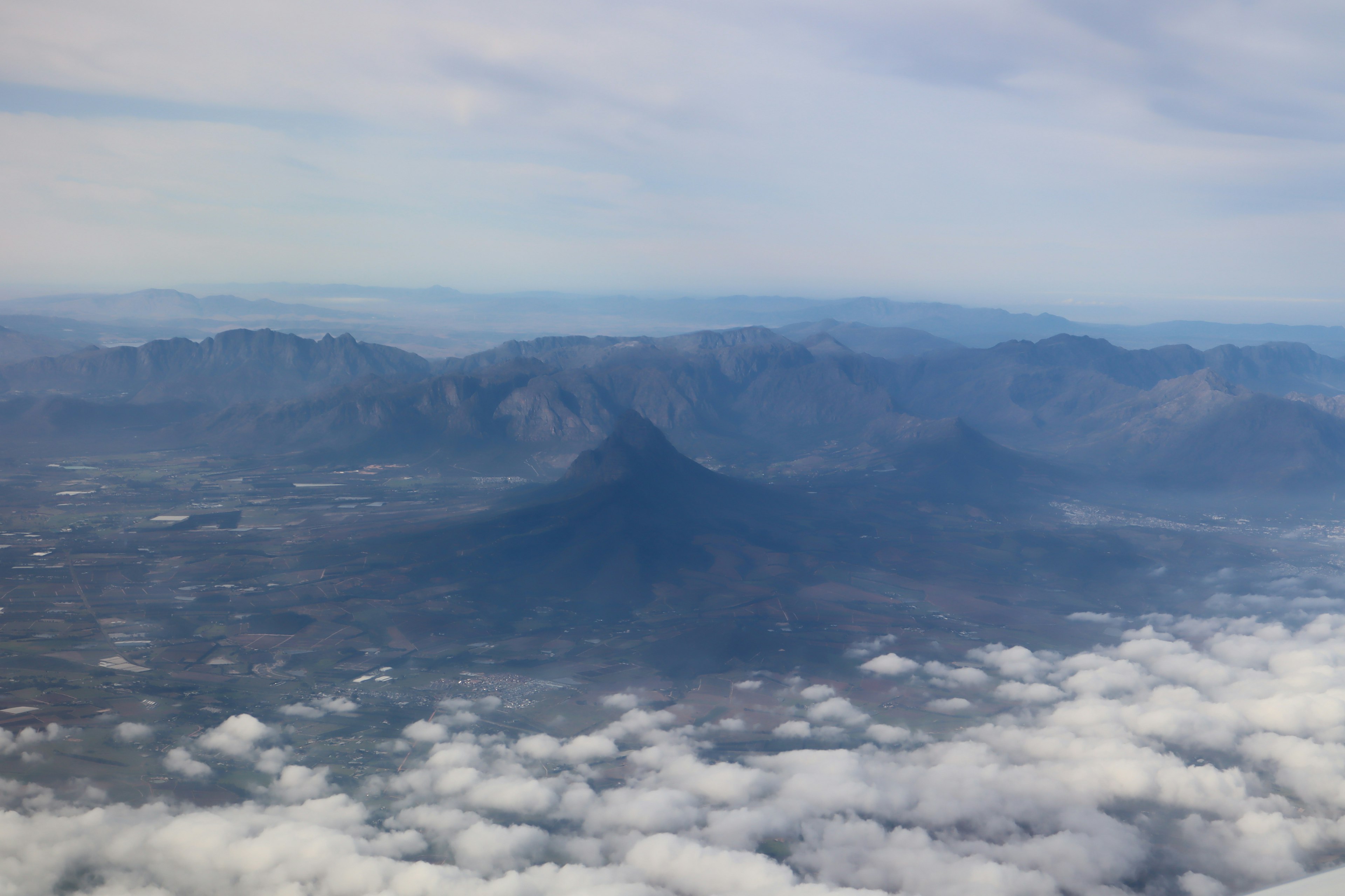 Vista aérea de montañas sobre las nubes con cielo azul