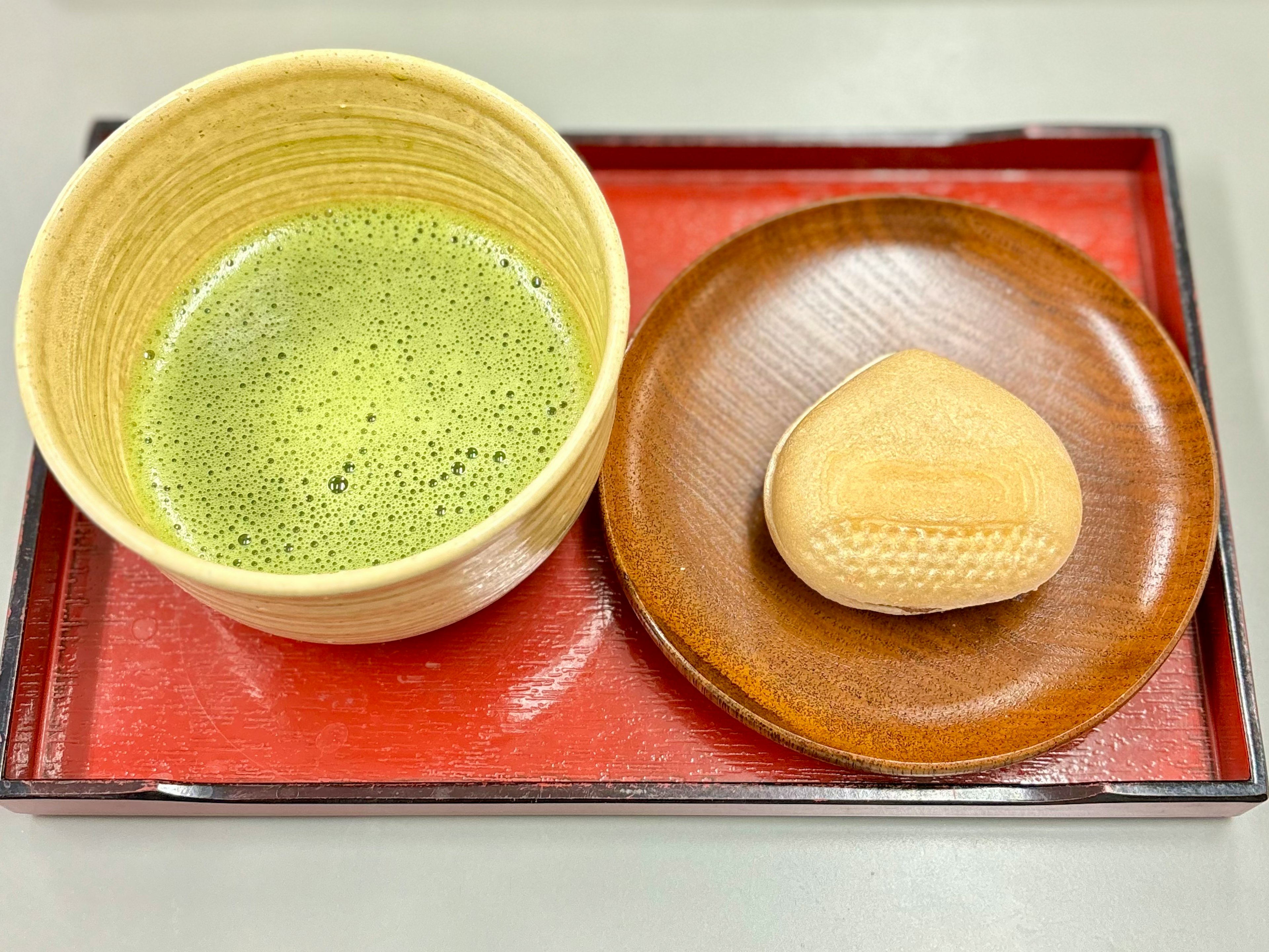 Un plateau avec du thé matcha et un bonbon japonais