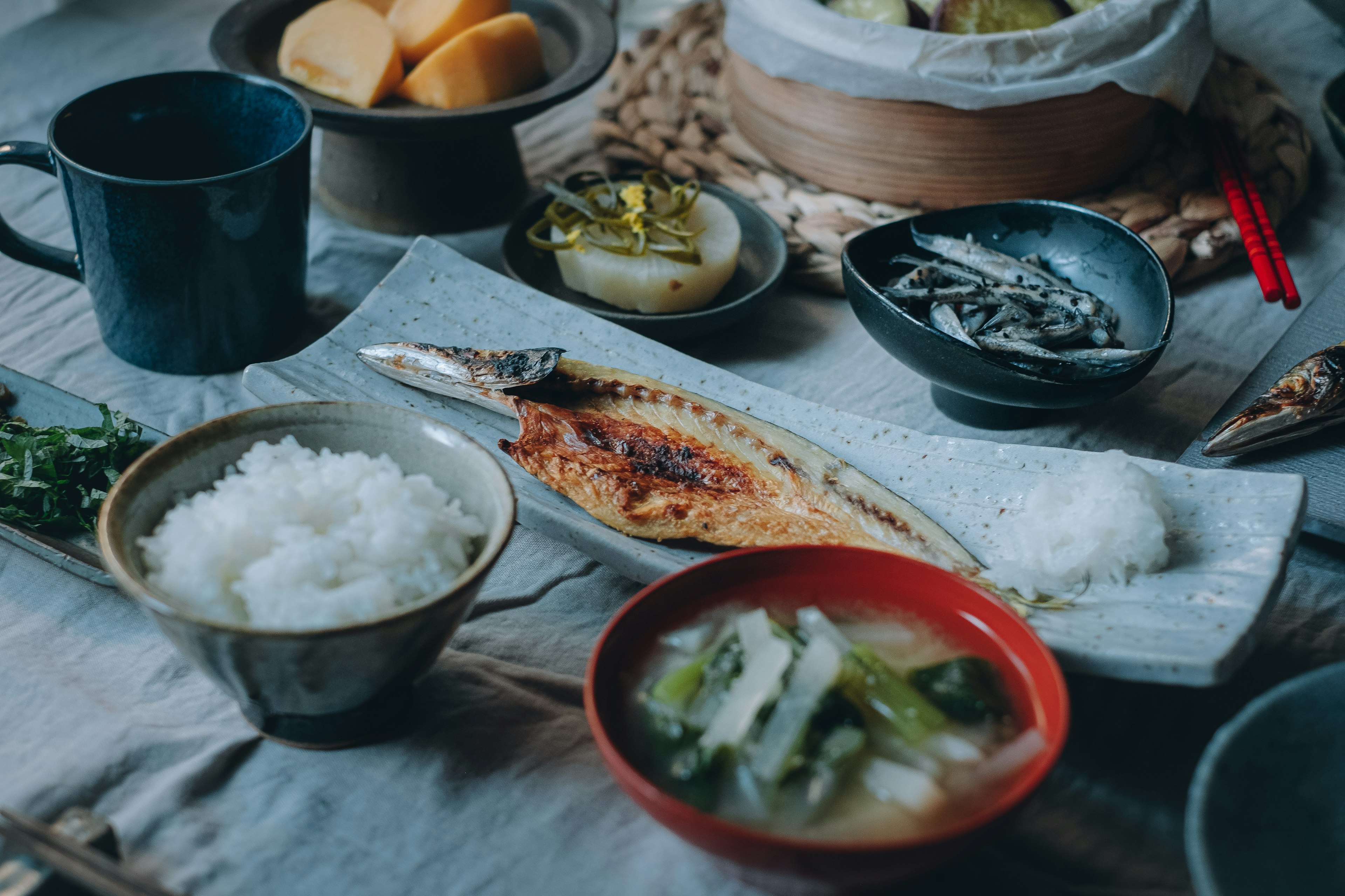 Japanese breakfast featuring grilled fish and rice served in traditional dishes