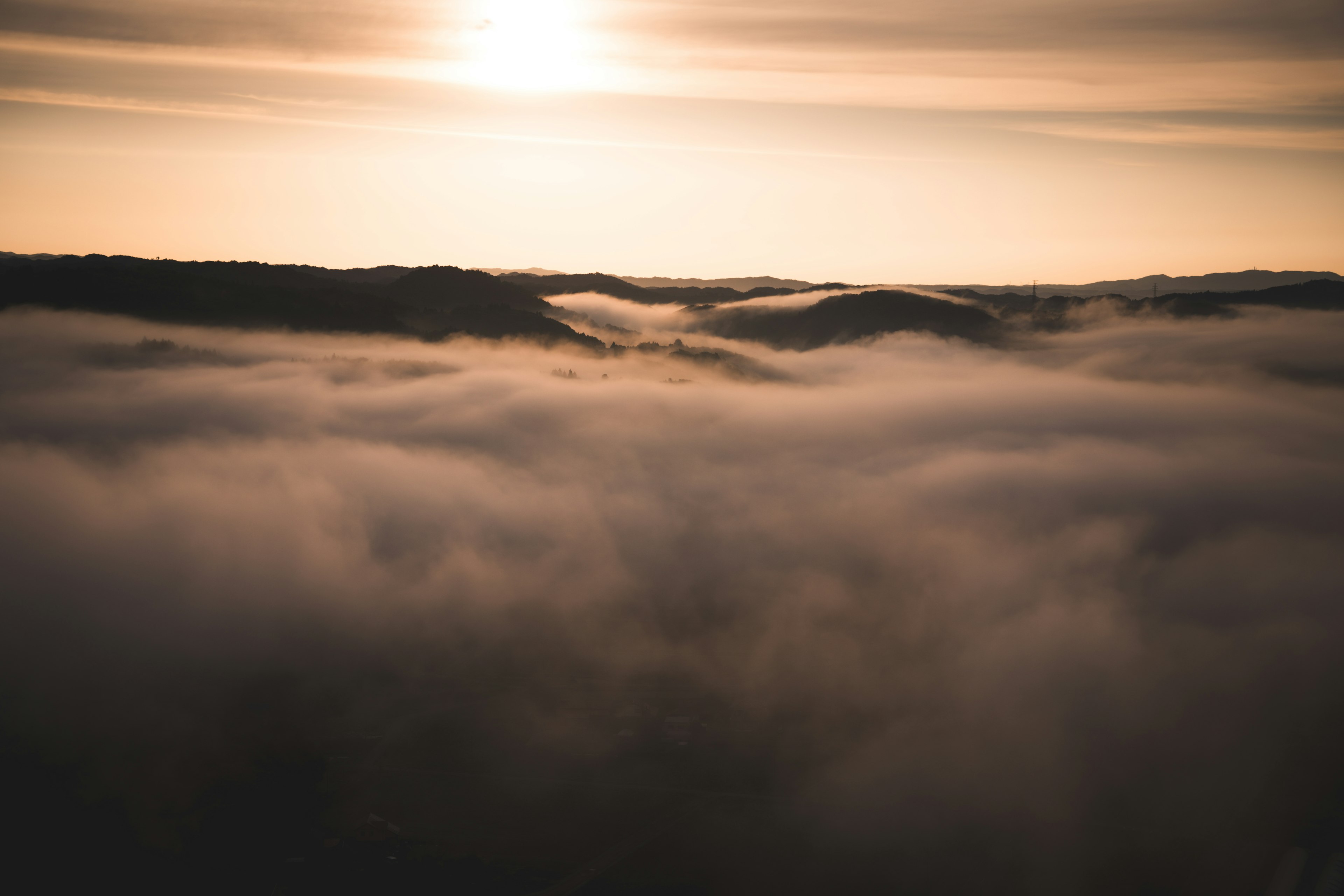 Sunlight breaking through fog over rolling hills