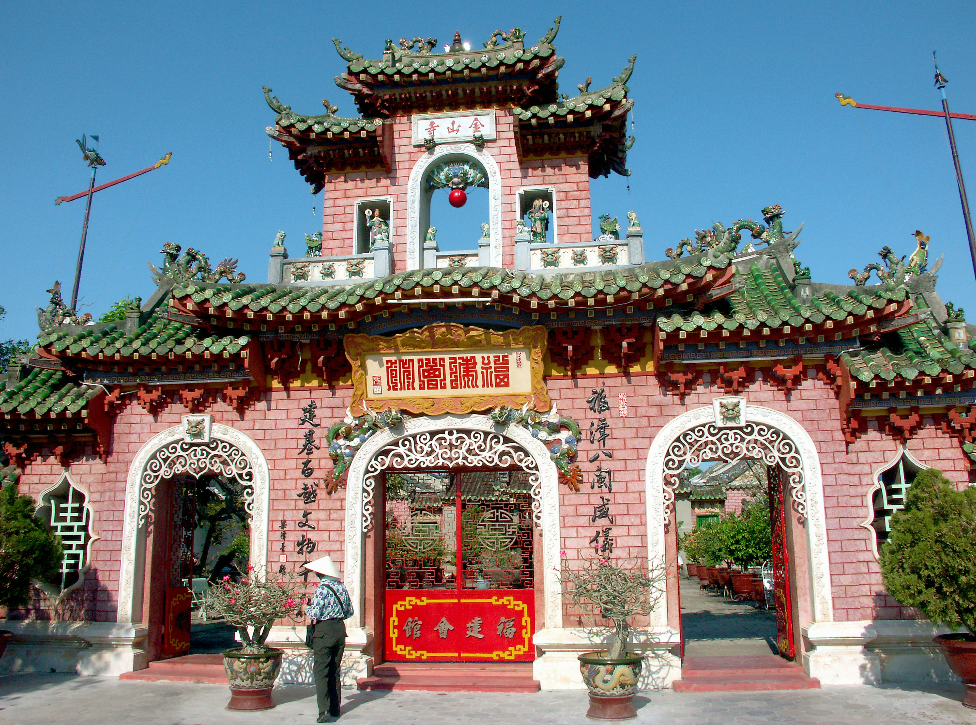 Vibrant Chinese-style temple exterior with red decorations and green roof