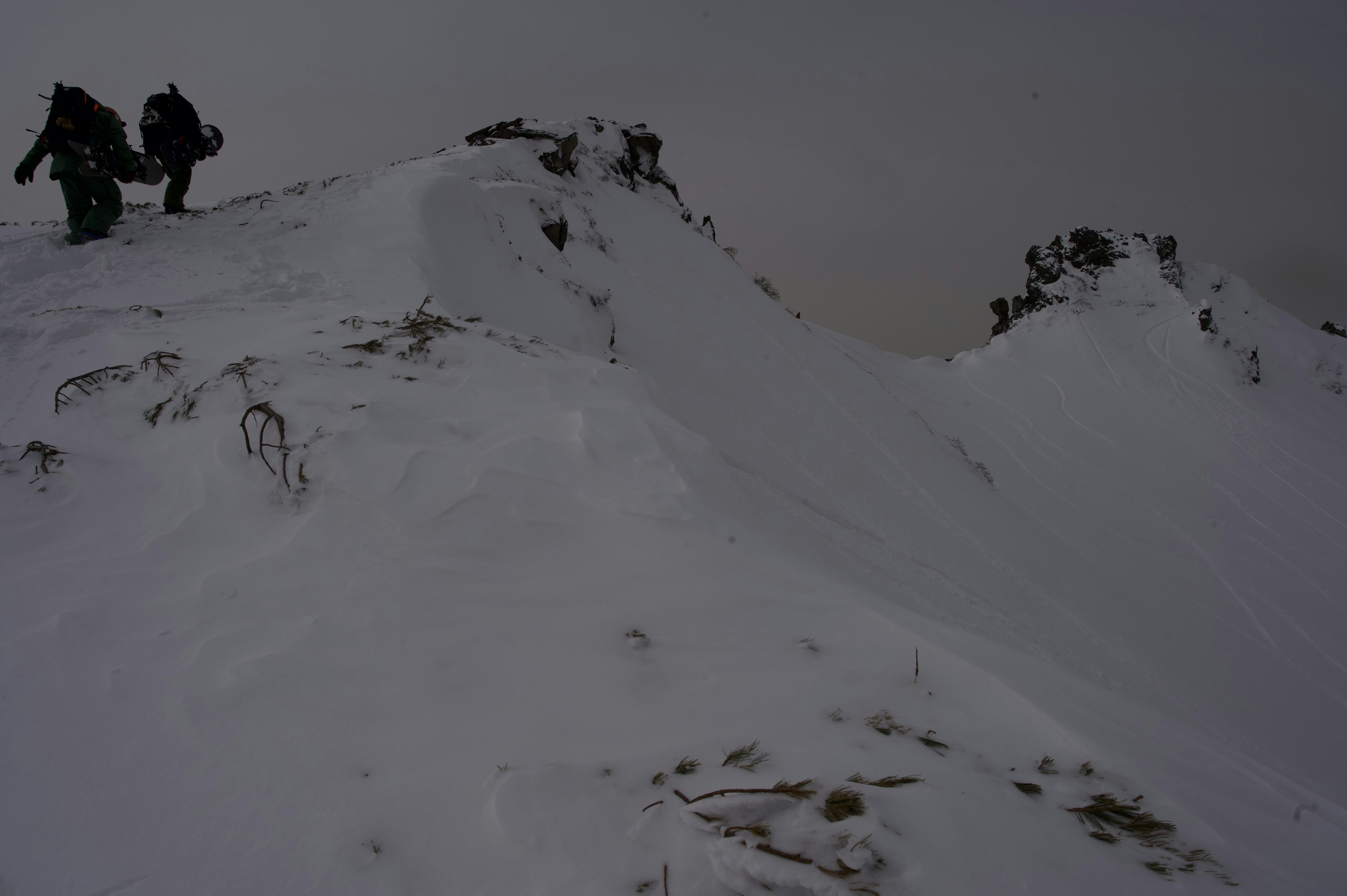 Escaladores navegando por un pico nevado bajo un cielo nublado