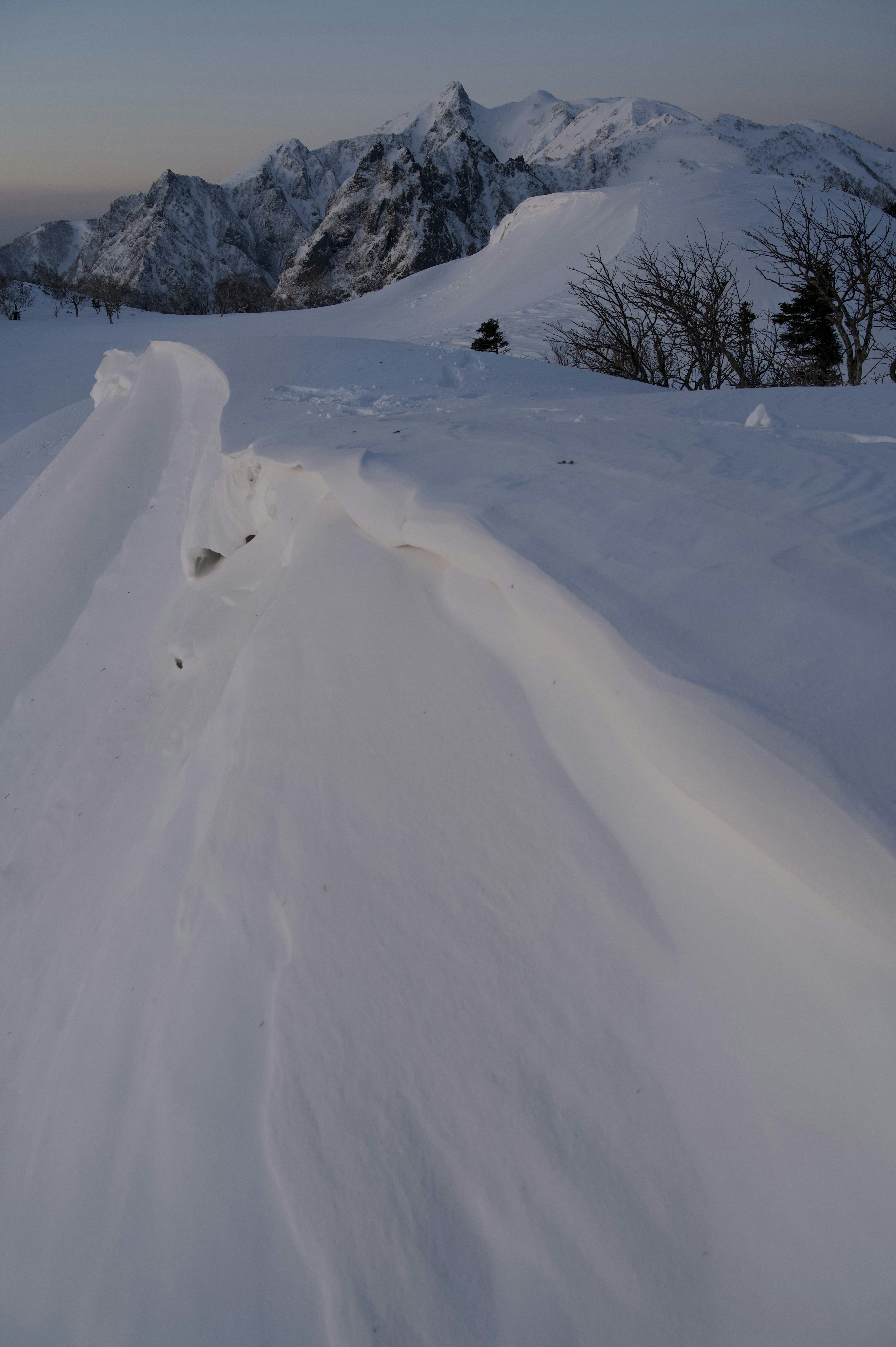 Snow-covered mountain landscape with smooth snow lines