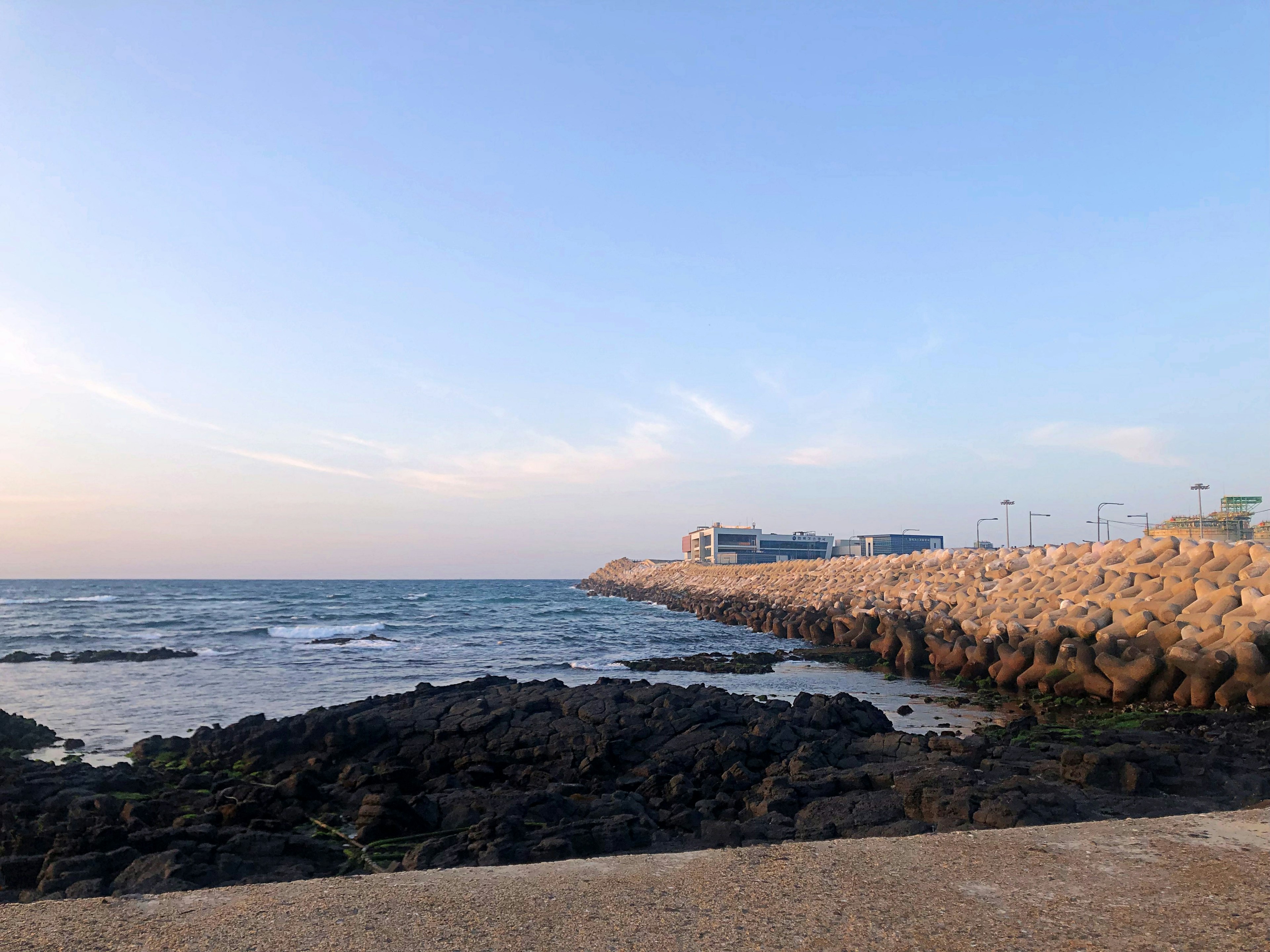 Küstenansicht mit Felsen und ruhigem Meer bei Sonnenuntergang