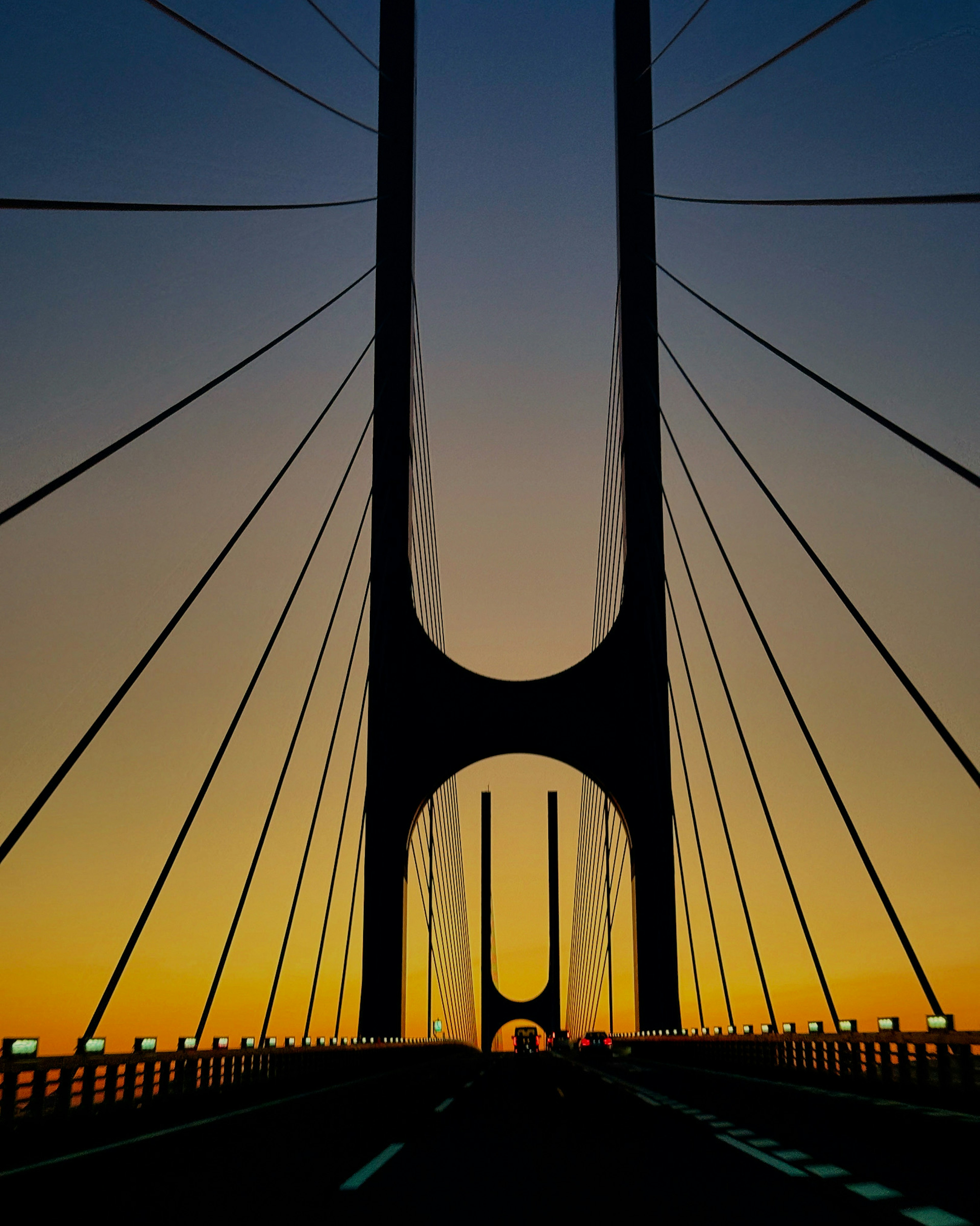 Silhouette d'un pont au coucher du soleil avec des câbles