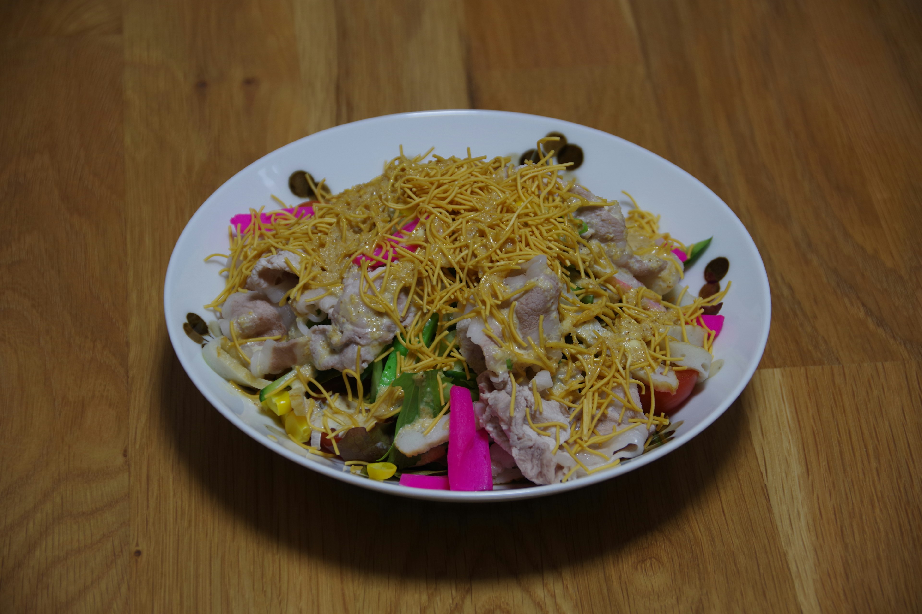 Salad berwarna-warni dengan ayam yang ditaburi dengan topping renyah