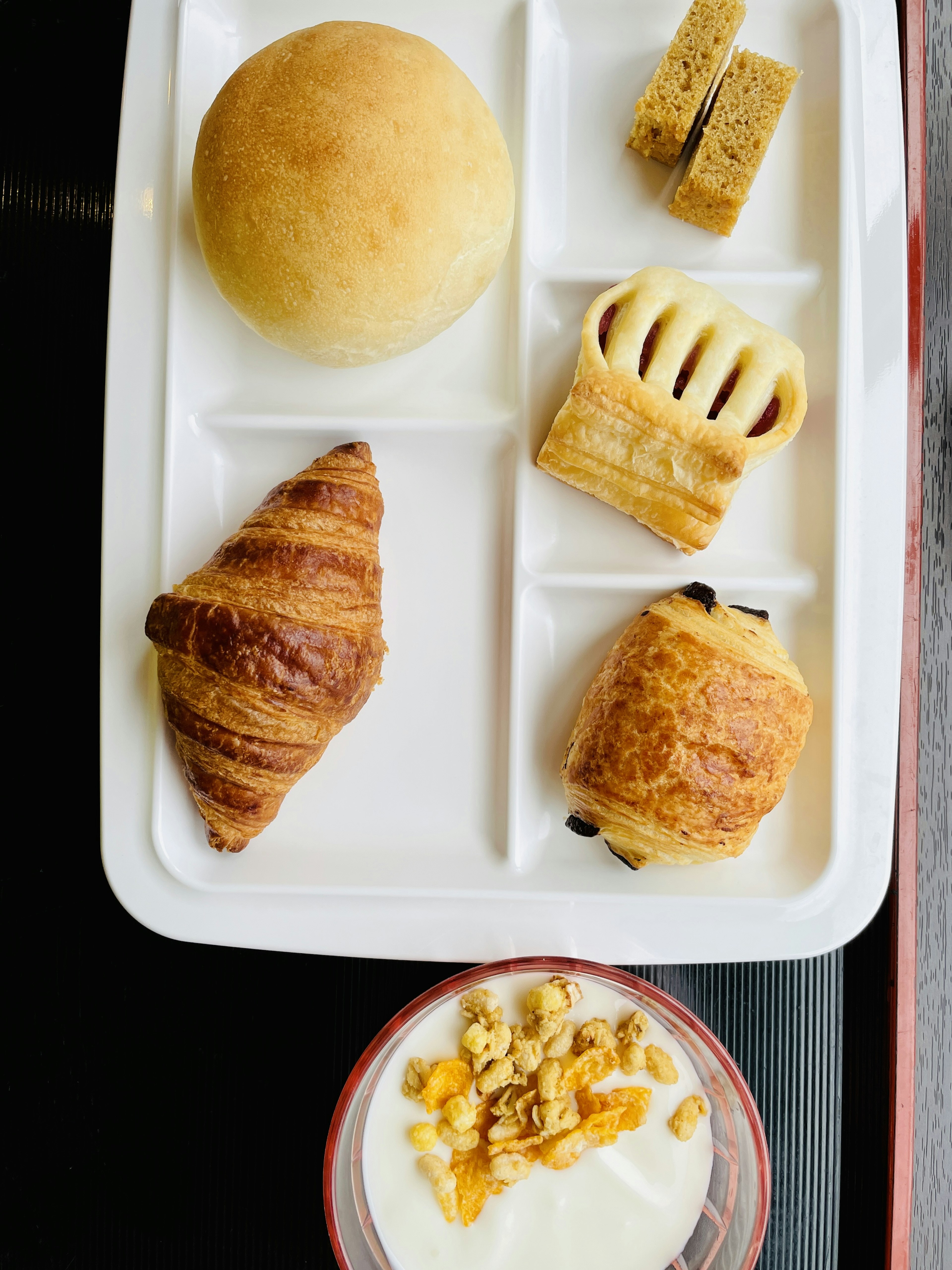 Bandeja de desayuno con pasteles variados y yogur