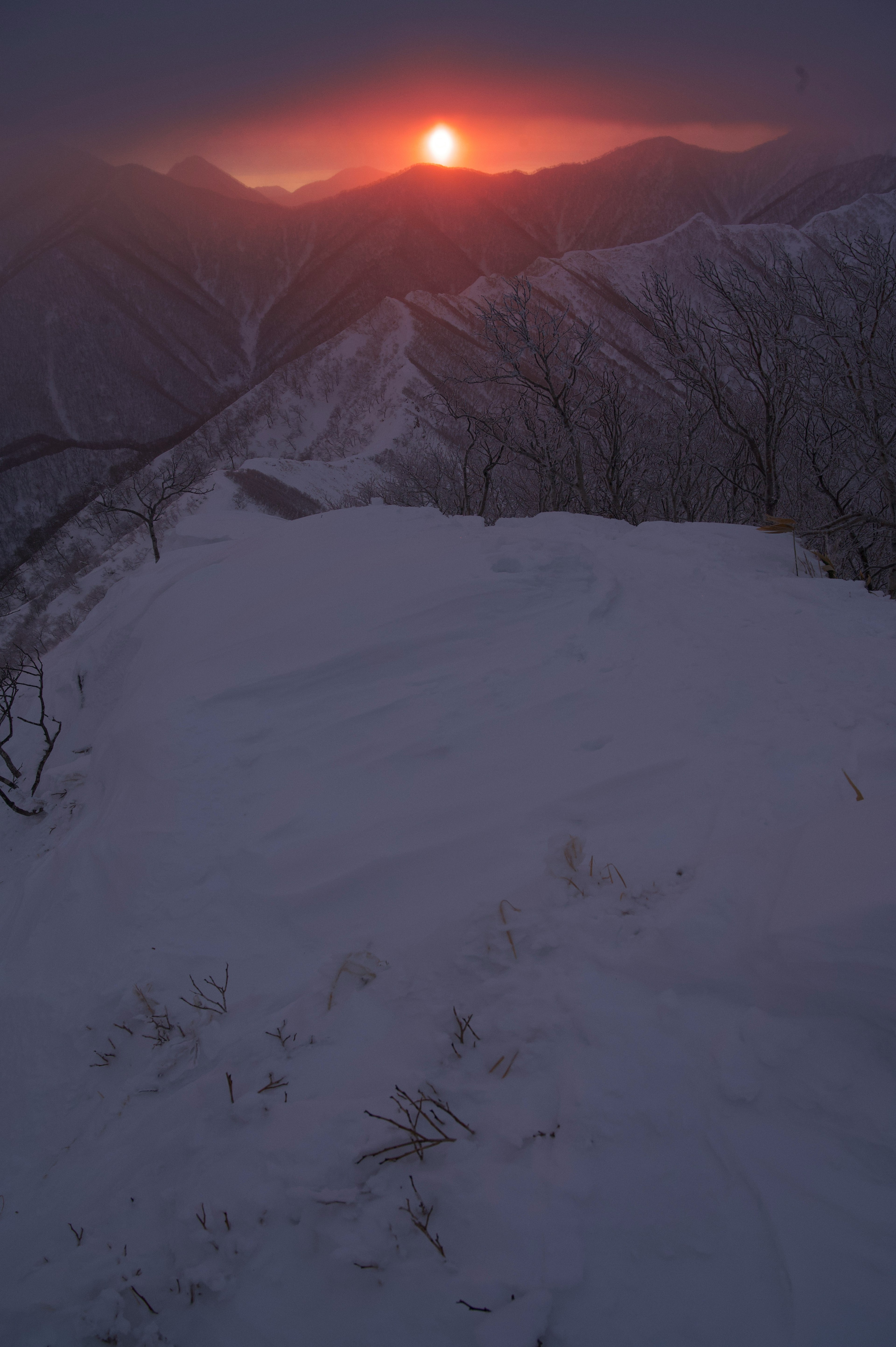 눈으로 덮인 산봉우리 위로 떠오르는 태양의 모습