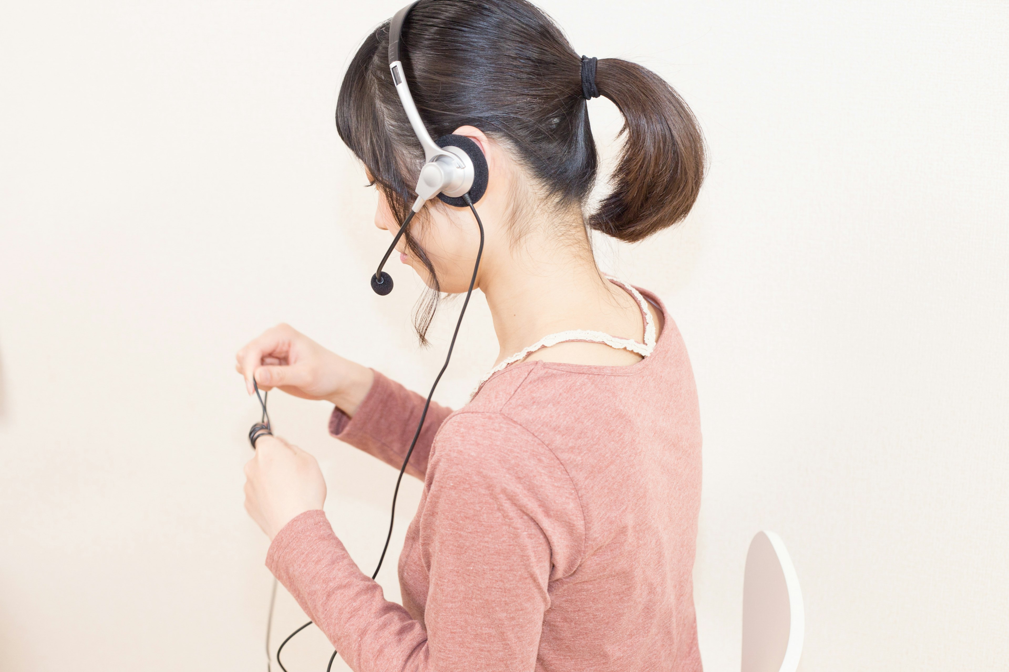 Frau mit Headset, die das Kabel anpasst