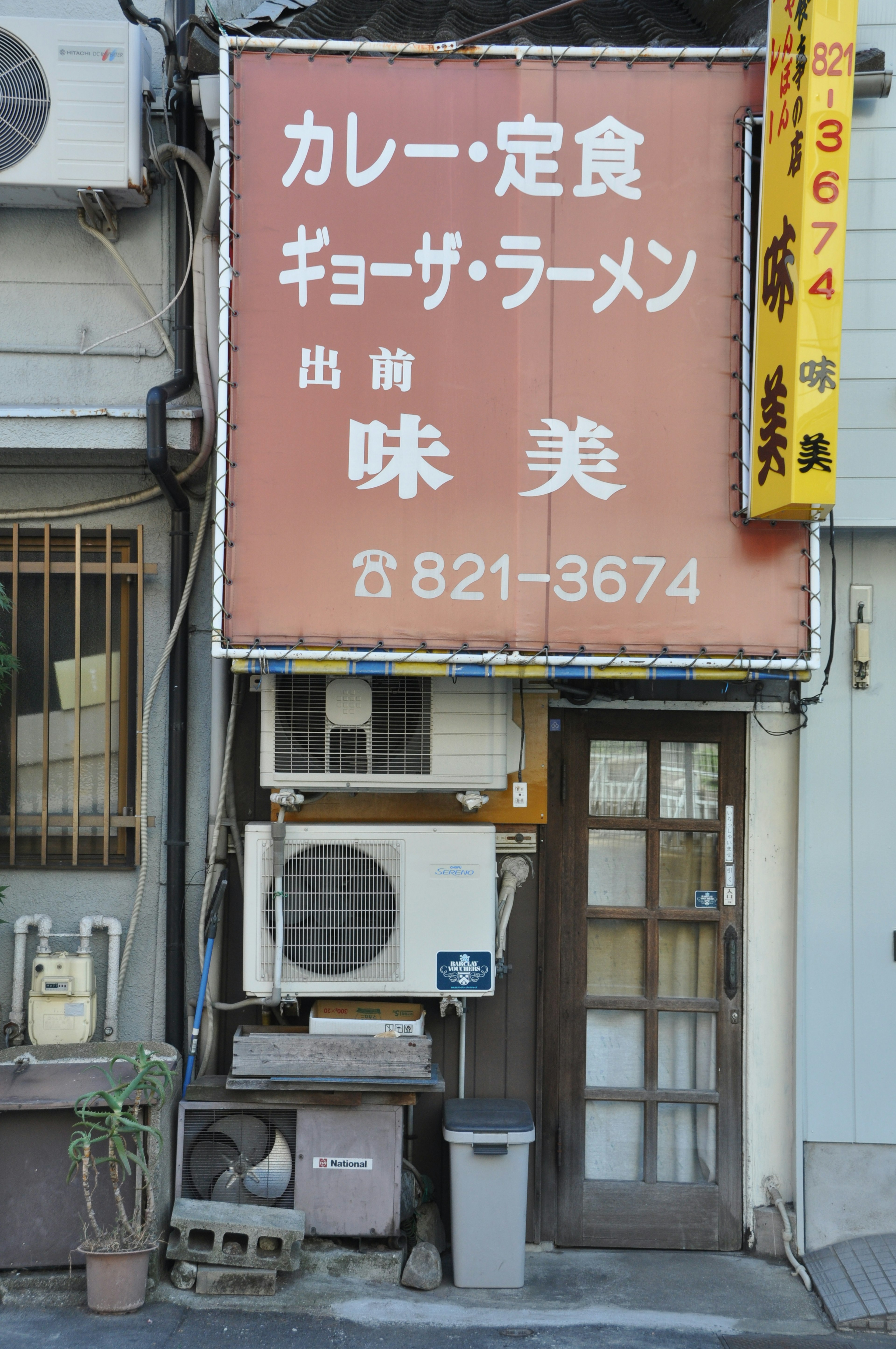 Façade d'un petit restaurant avec un panneau pour curry et repas fixes