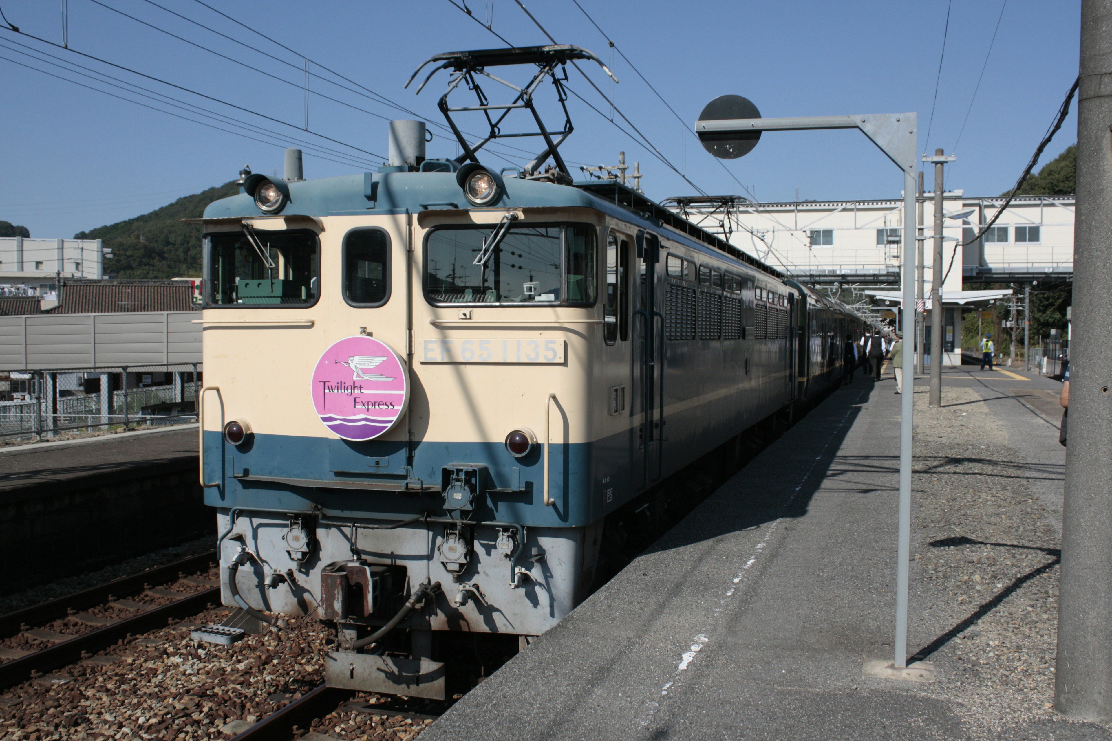 รถไฟสีน้ำเงินและสีครีมจอดที่สถานี