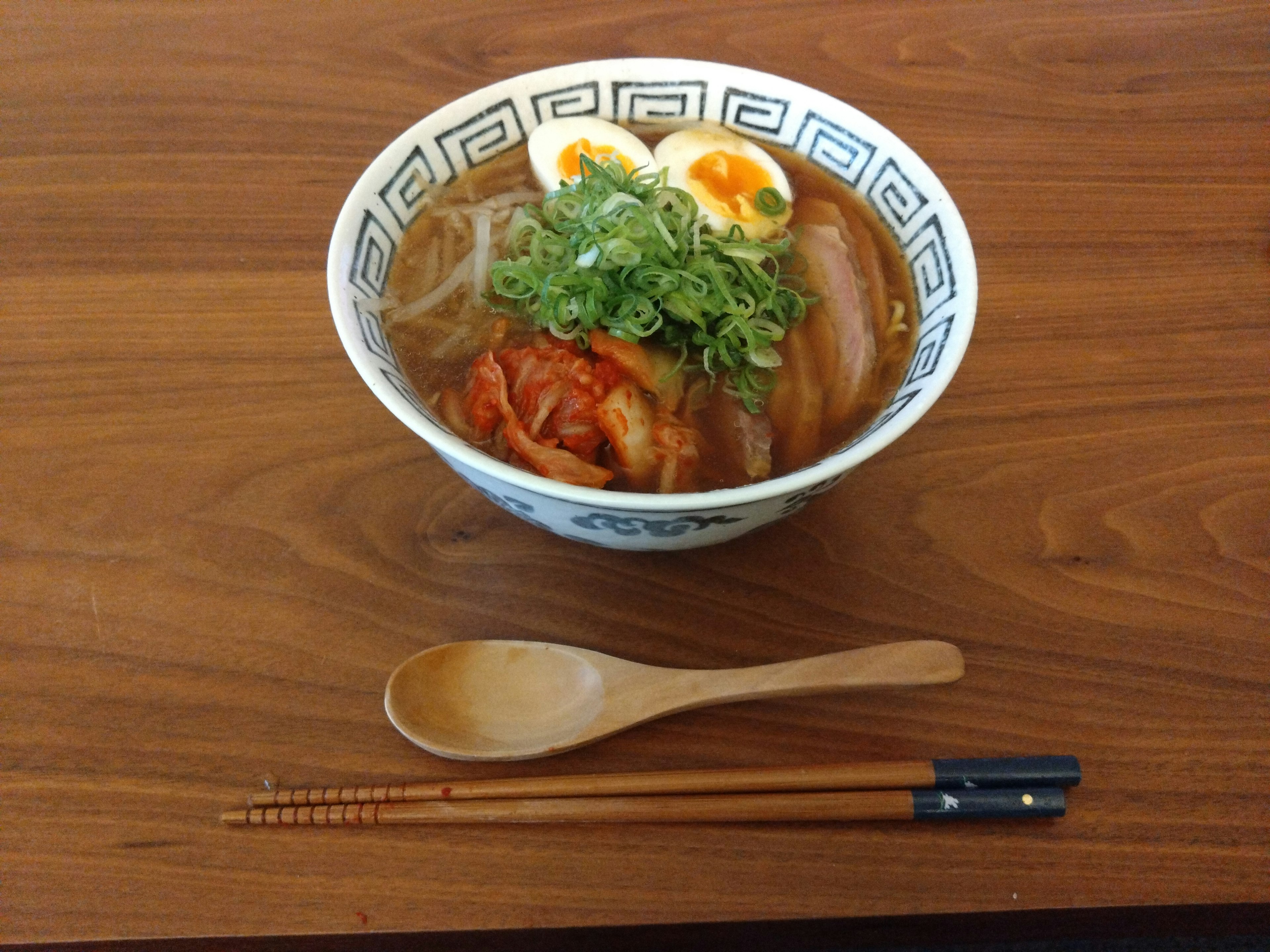 Una bella ciotola di ramen guarnita con uova sode e cipollotti