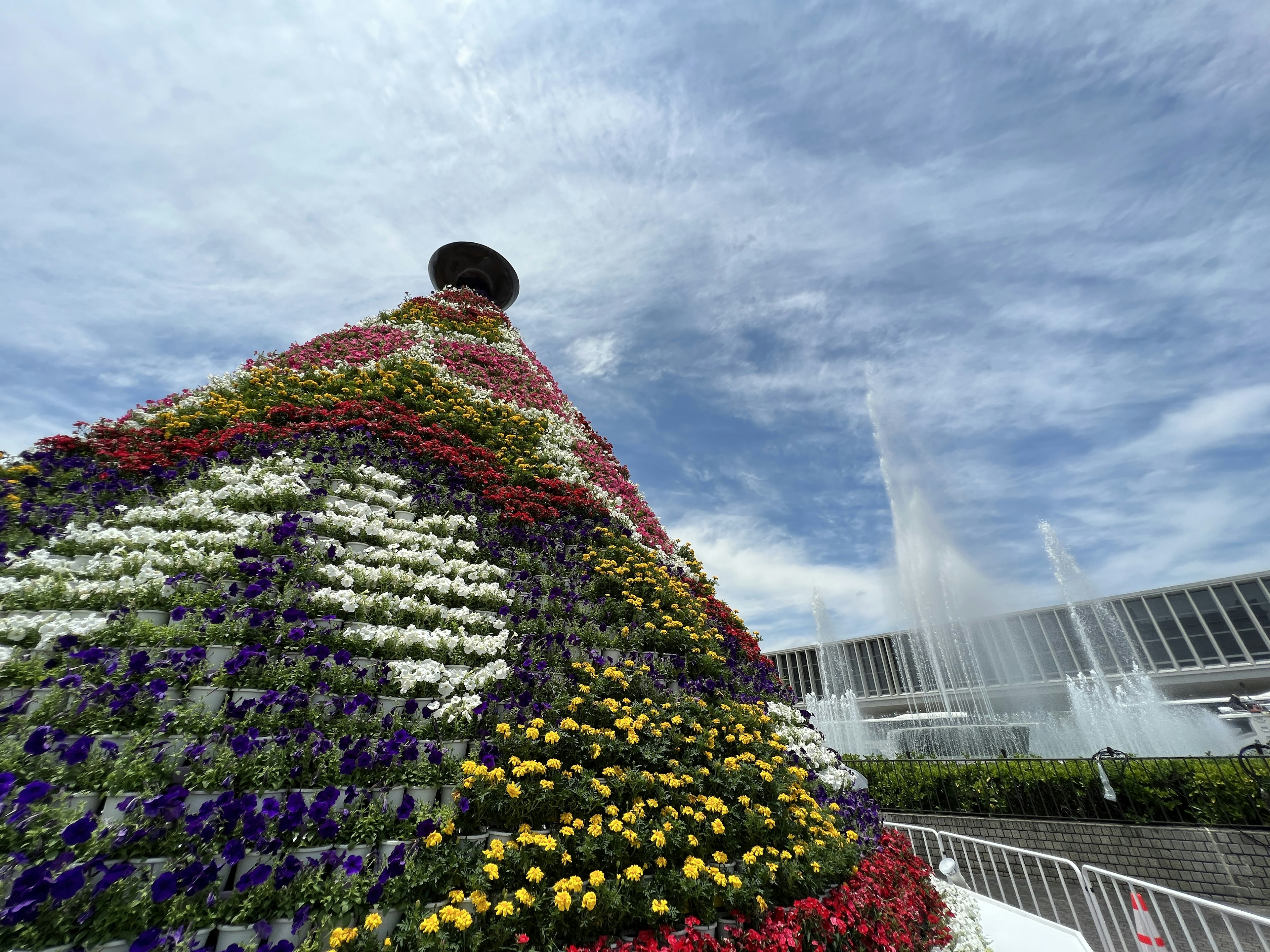 Gran estructura en forma de pirámide decorada con flores coloridas contra un cielo azul