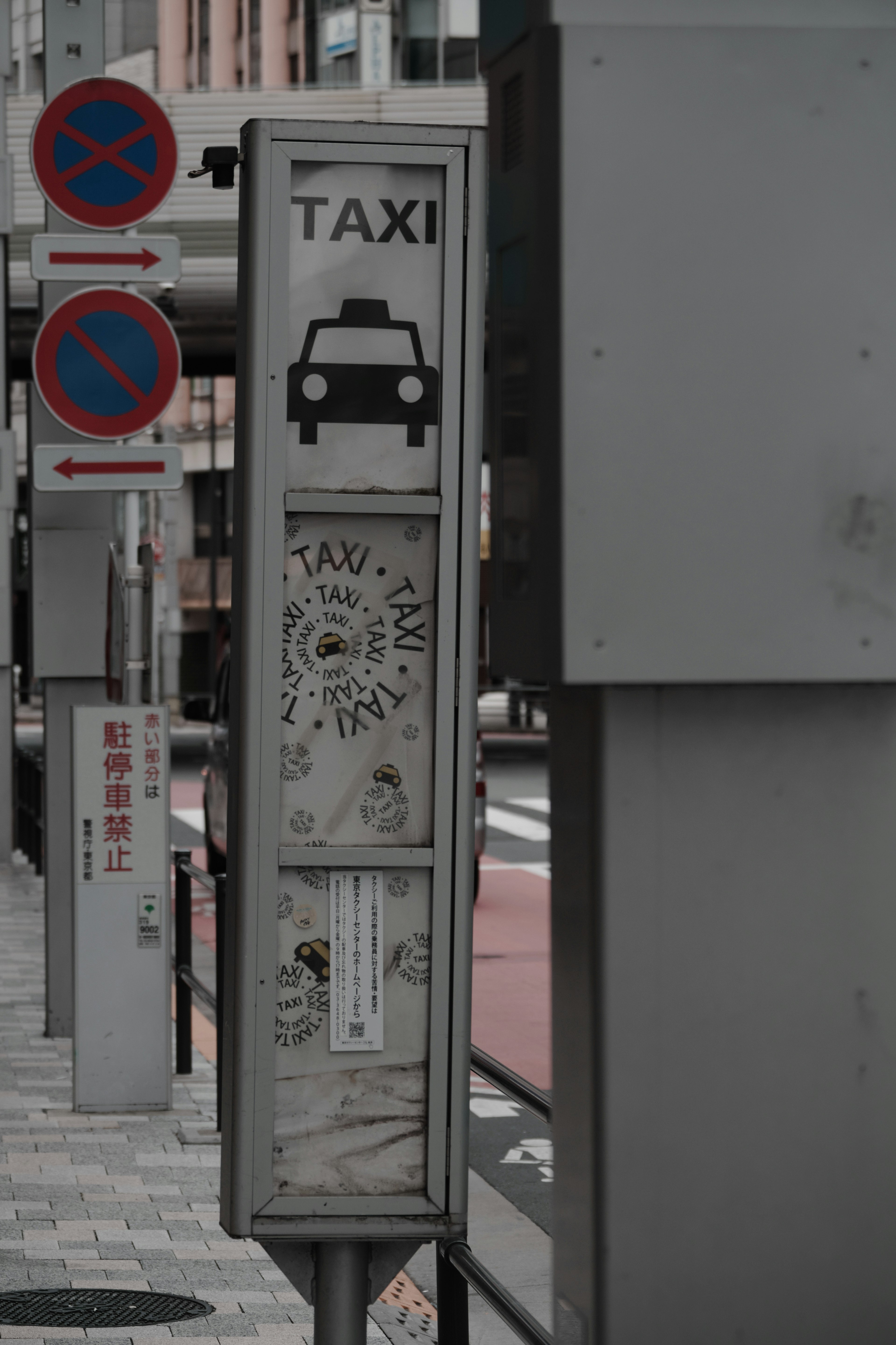 Segnale taxi con icona di taxi e segnali di divieto di sosta in un ambiente urbano