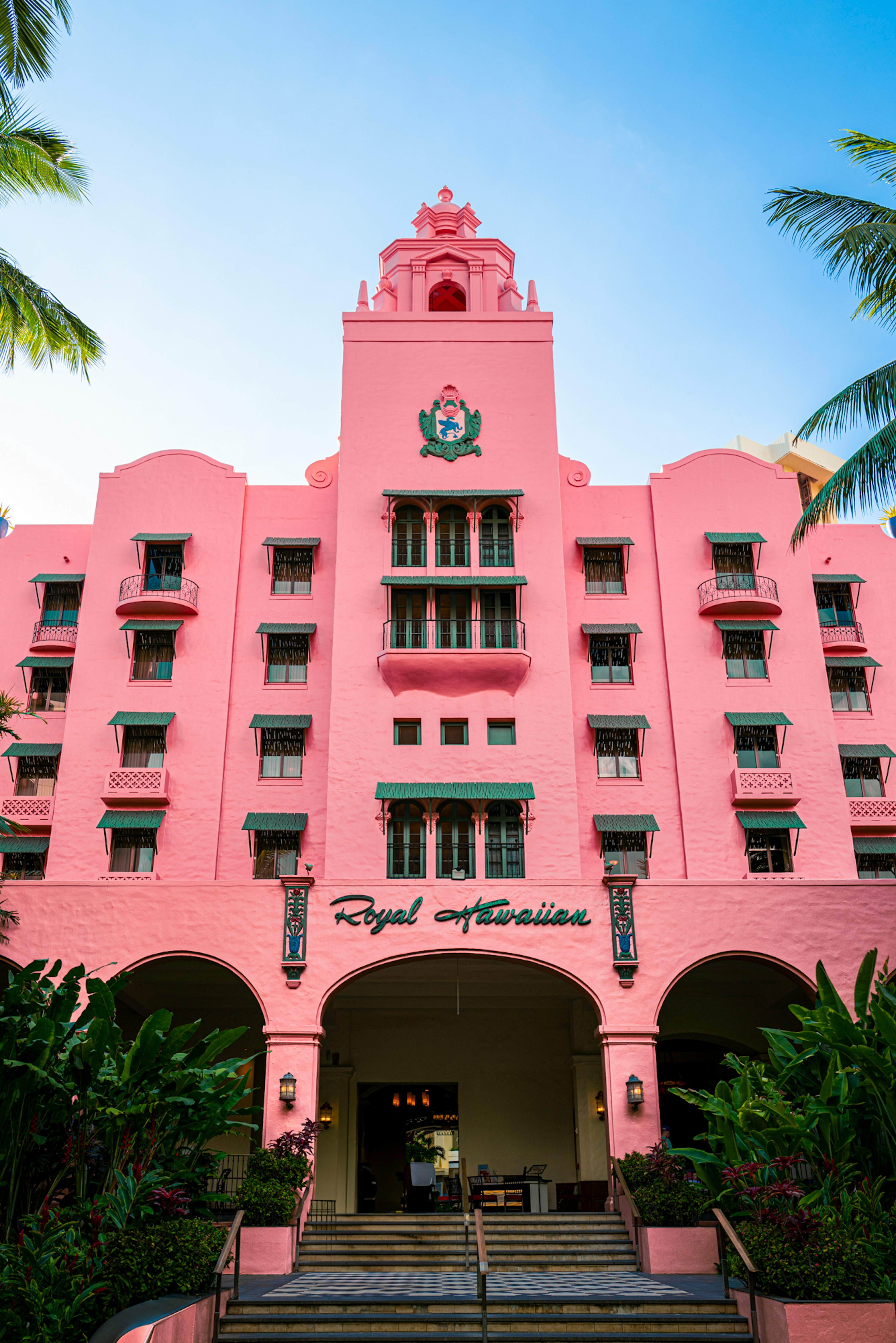 Facade of a tropical hotel with a pink exterior