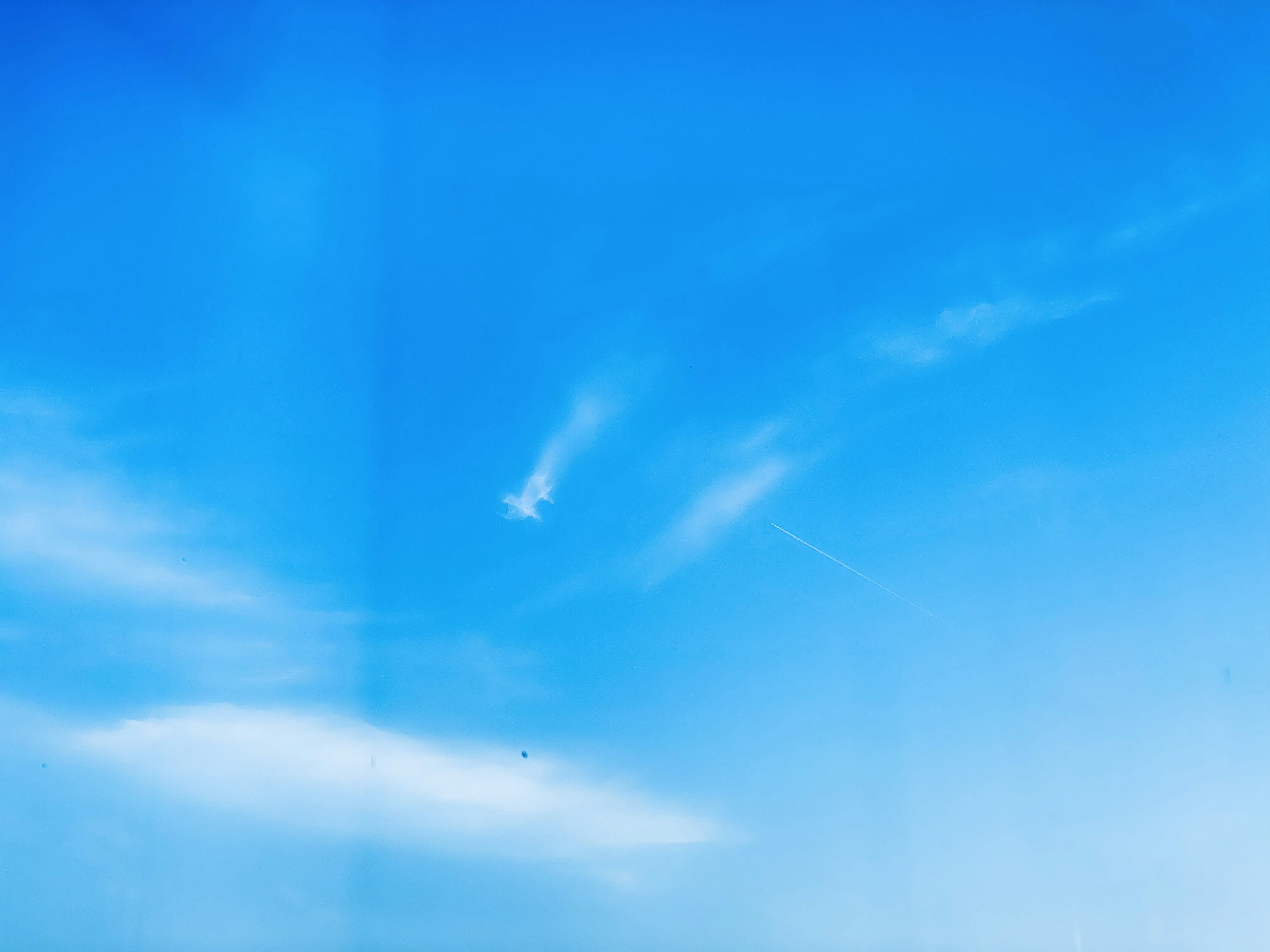 Heller blauer Himmel mit wispy weißen Wolken