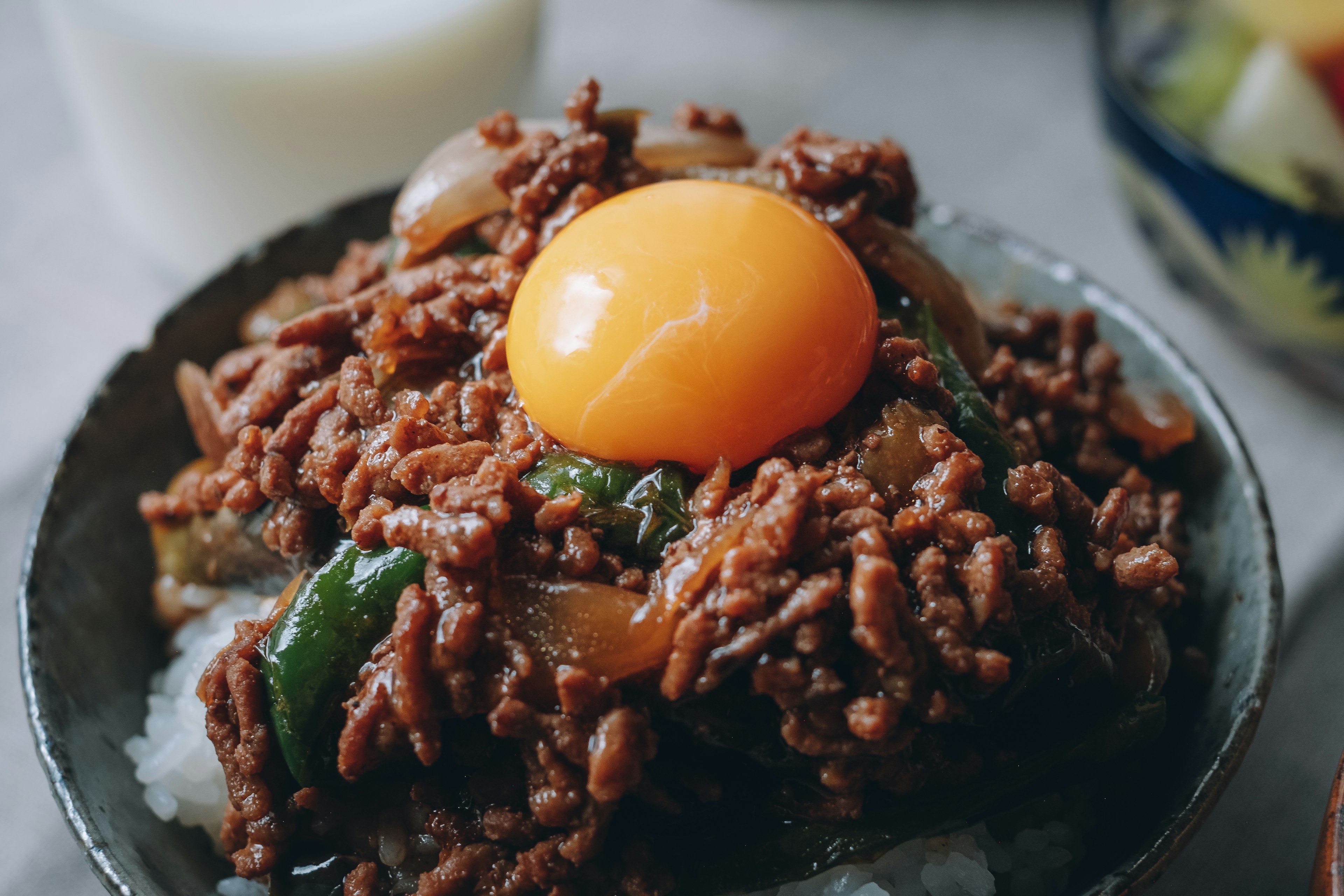 밥 위에 양념된 다진 고기와 날달걀이 올려진 그릇