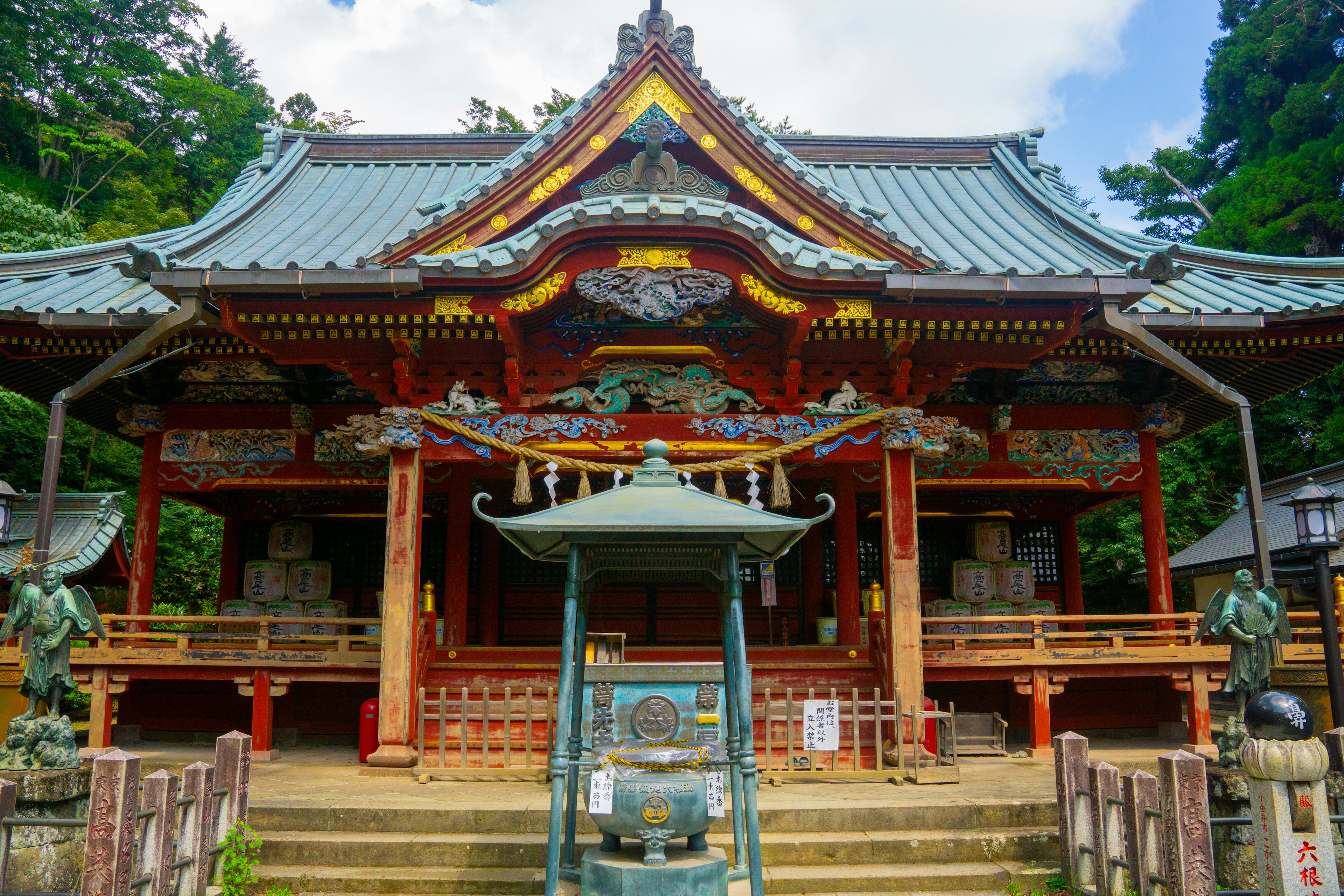 Traditional shrine architecture surrounded by greenery showcasing intricate details