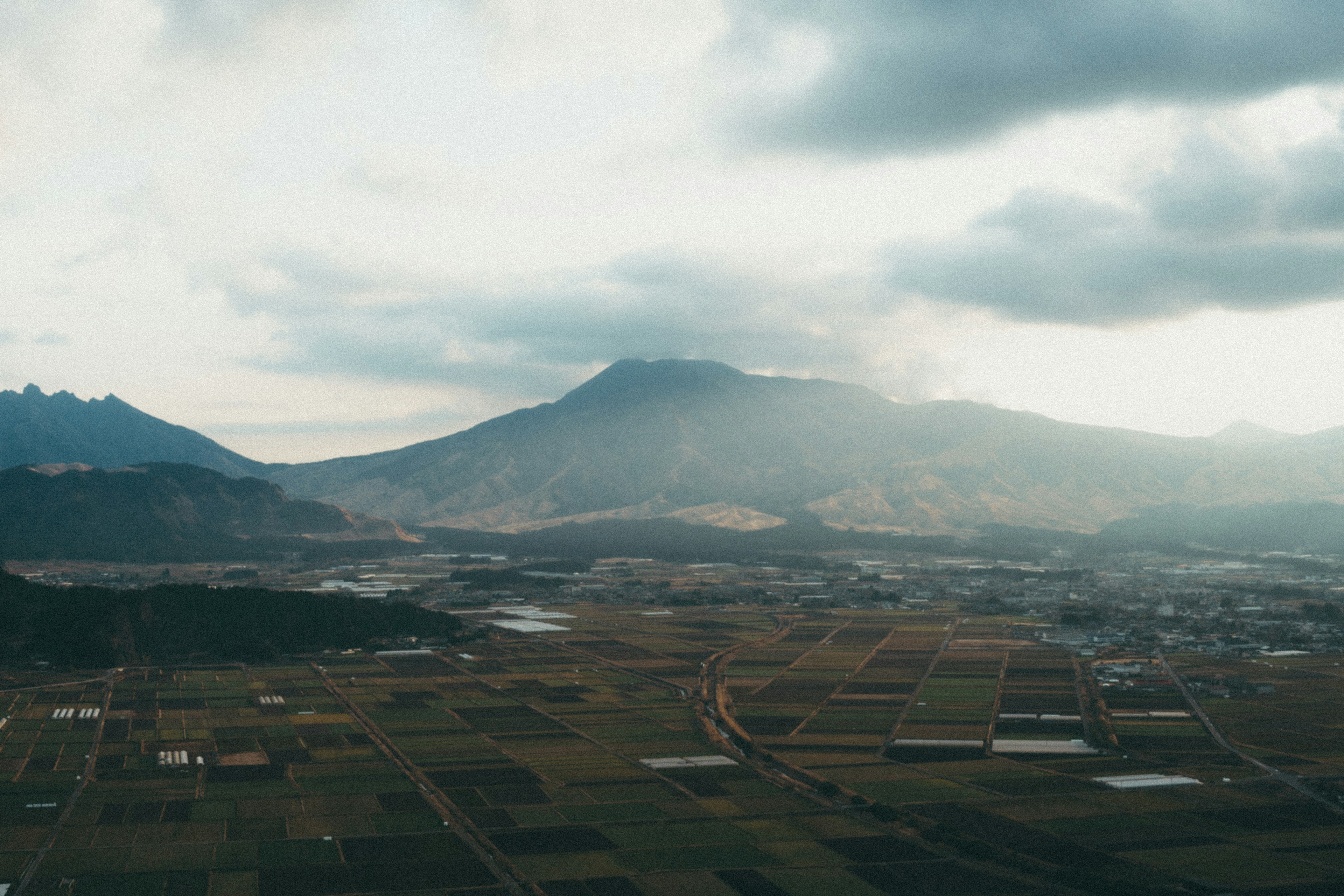 Paesaggio ampio con terreni agricoli e montagne