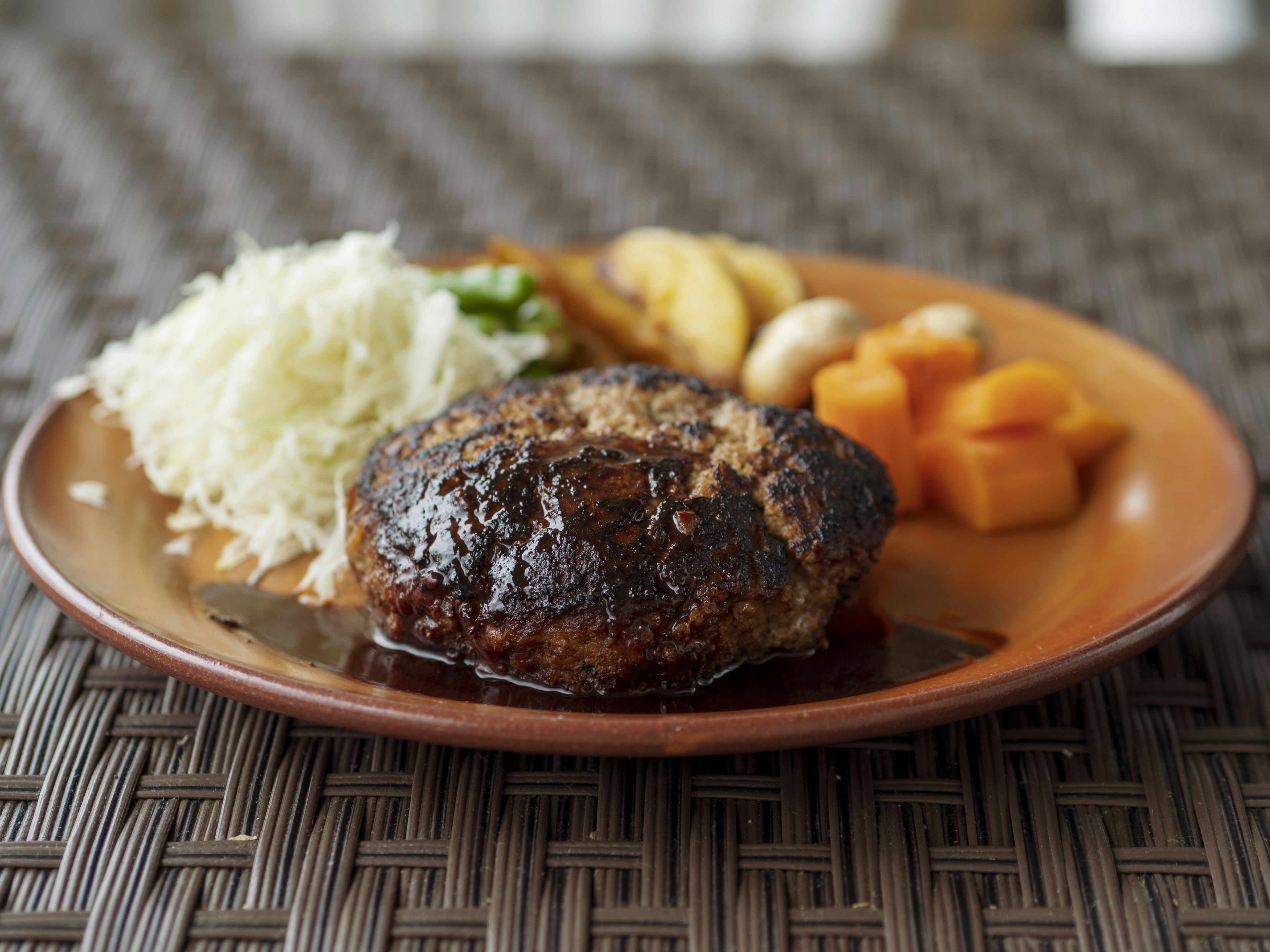 Piring dengan steak hamburger, nasi, dan sayuran campuran