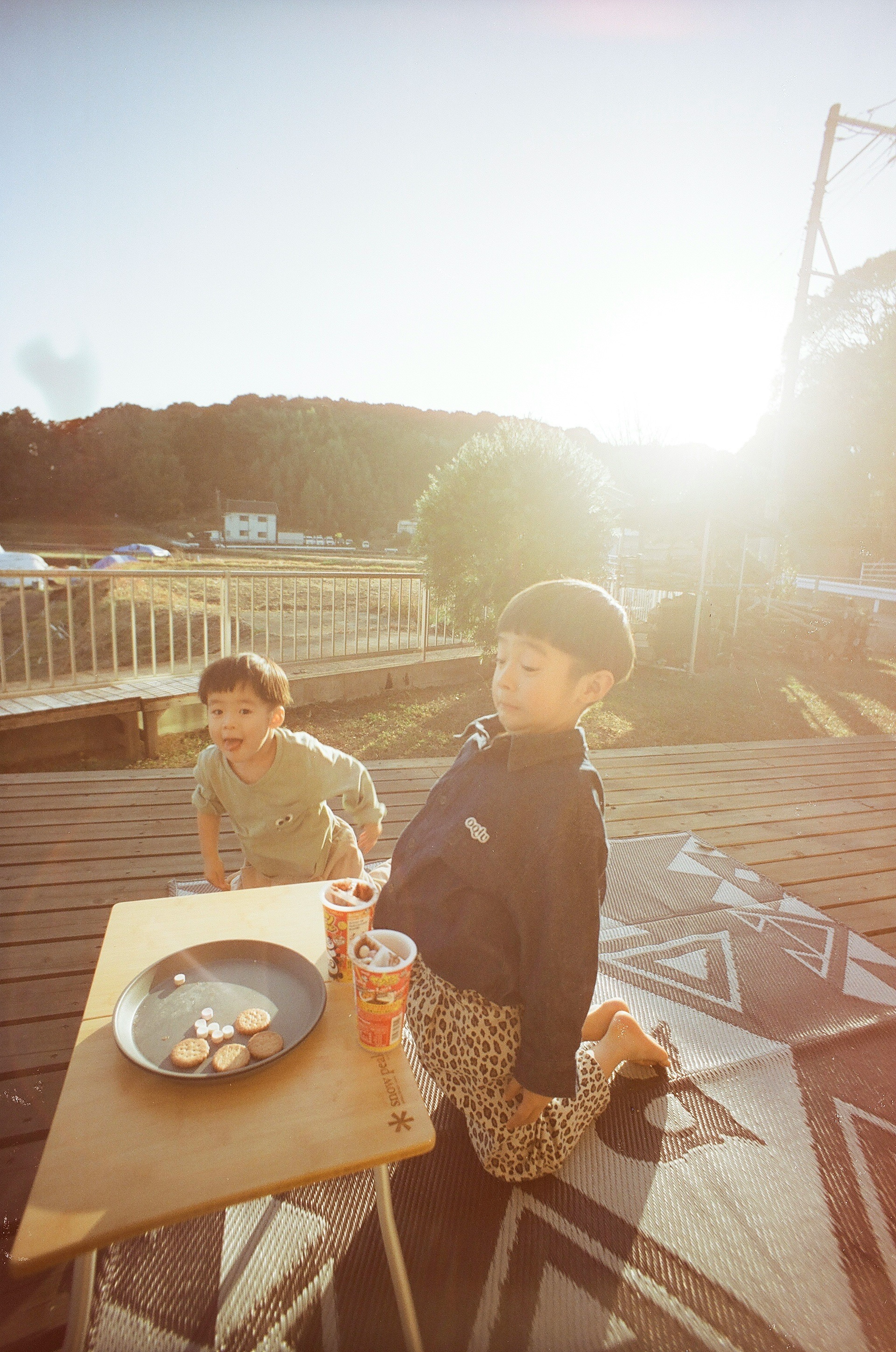 Children playing in front of a table during sunset