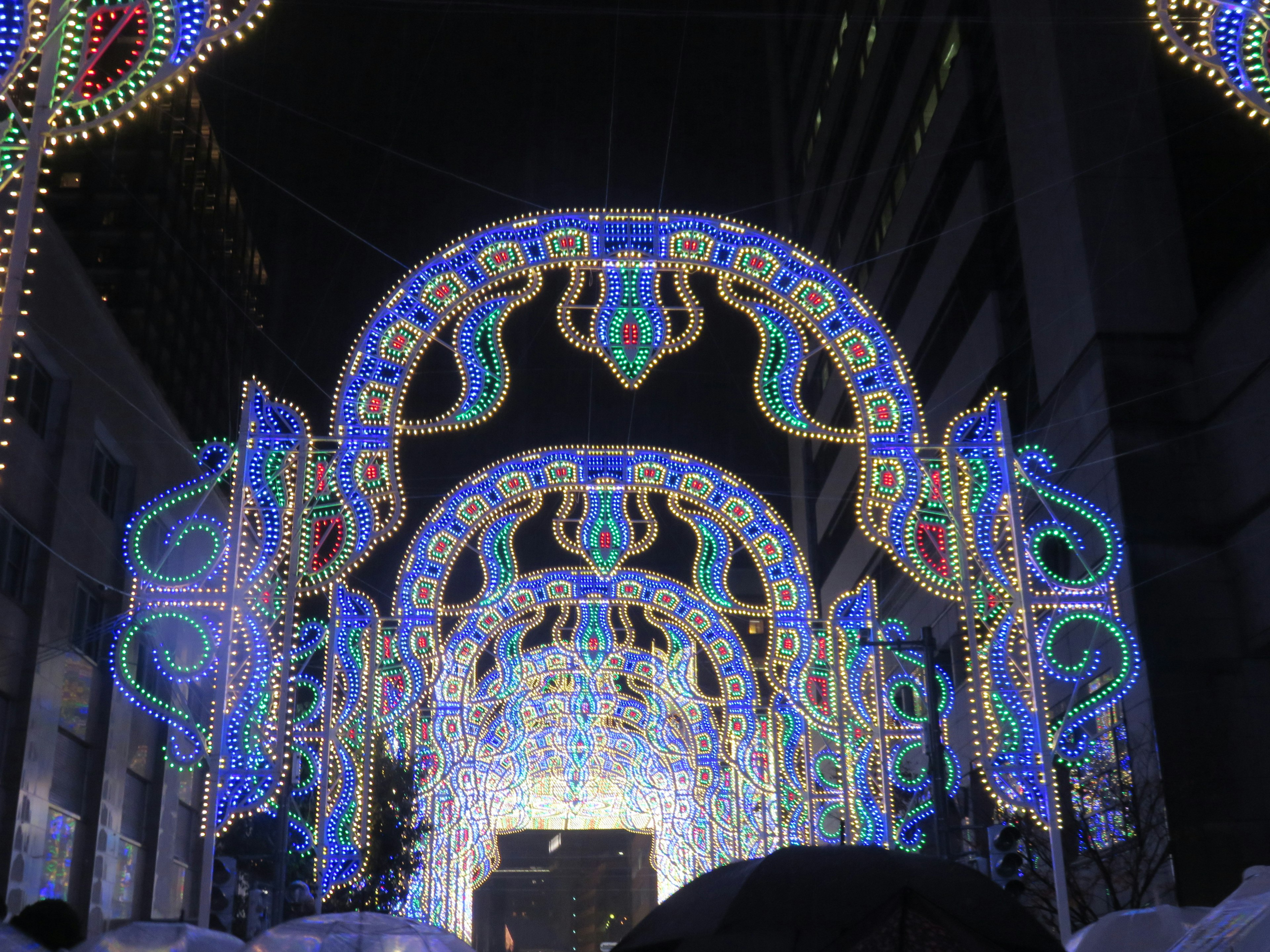 Arcos iluminados en luces azules y blancas bajo el cielo nocturno