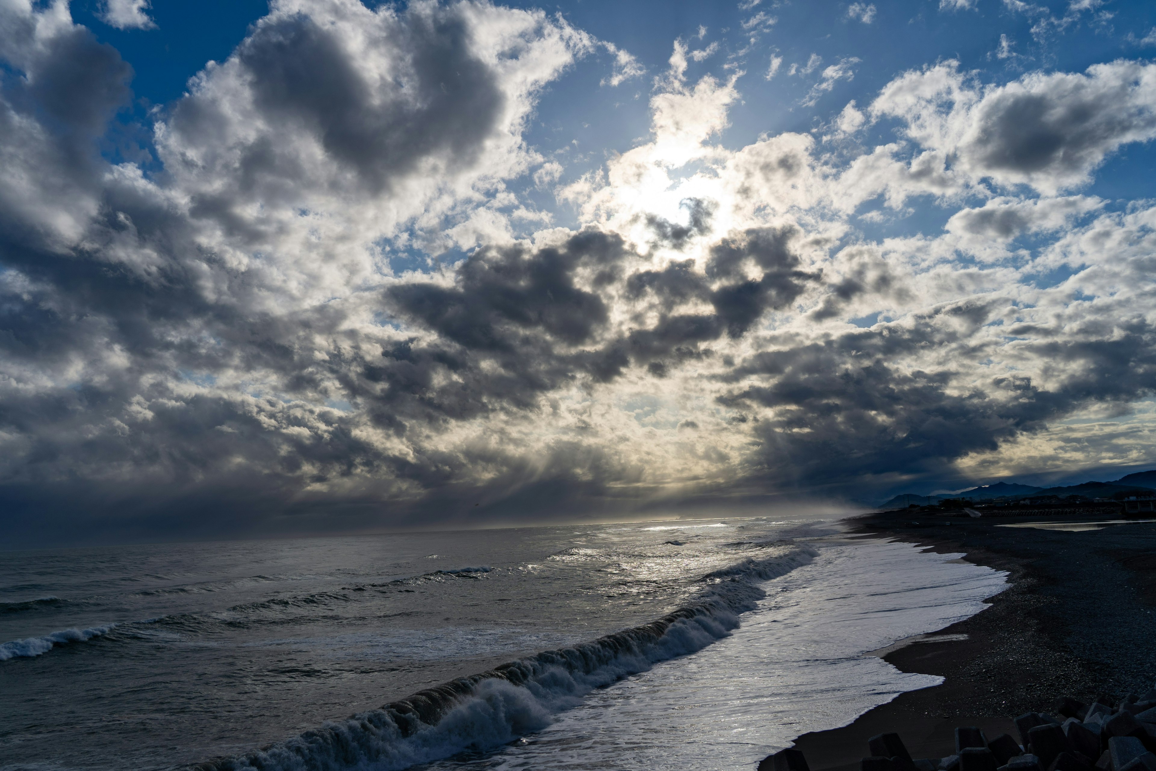 海岸線と雲の表情を映し出した夕暮れの海の風景