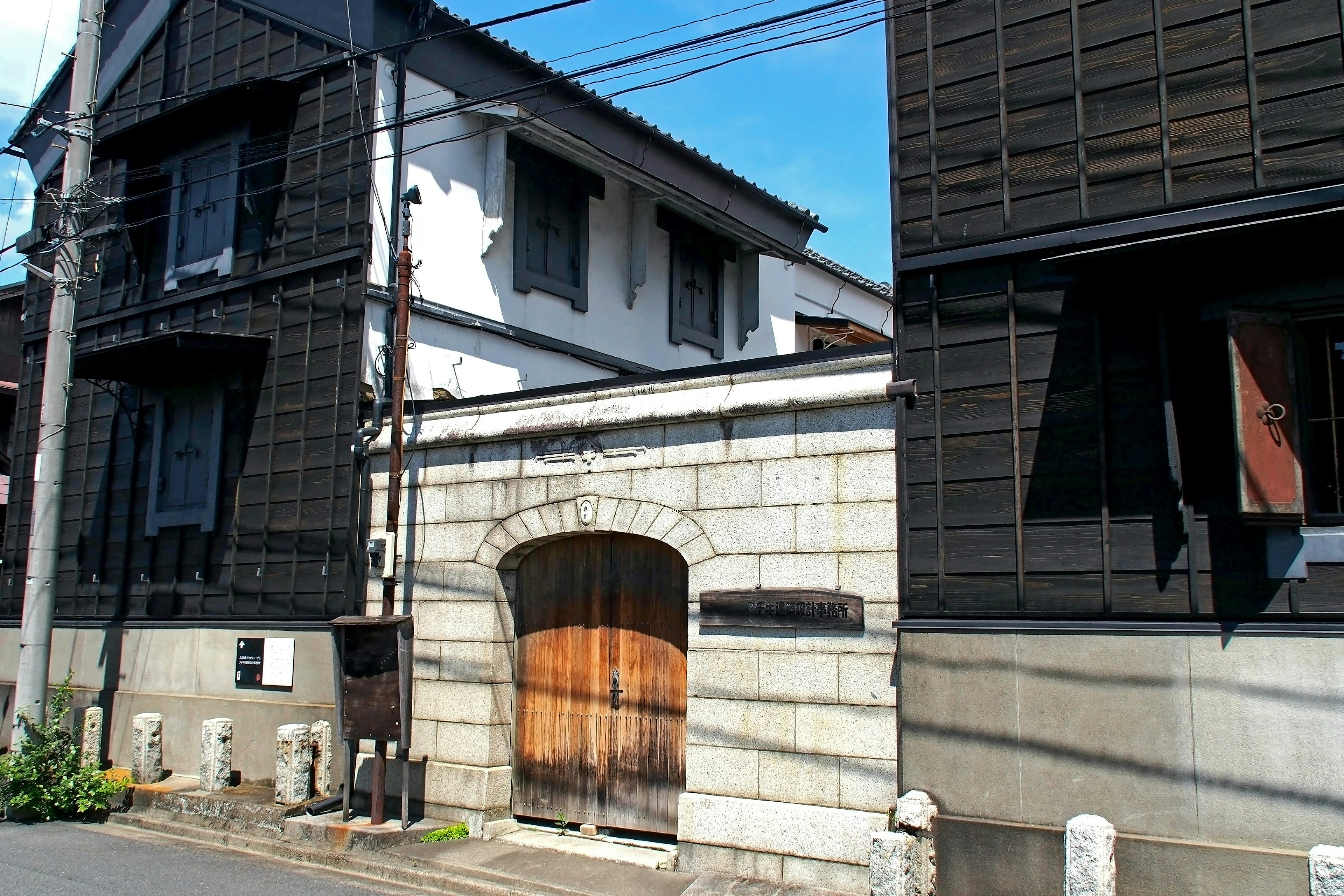 Traditionelle japanische Häuser mit schwarzen Außenwänden und einem Steintor