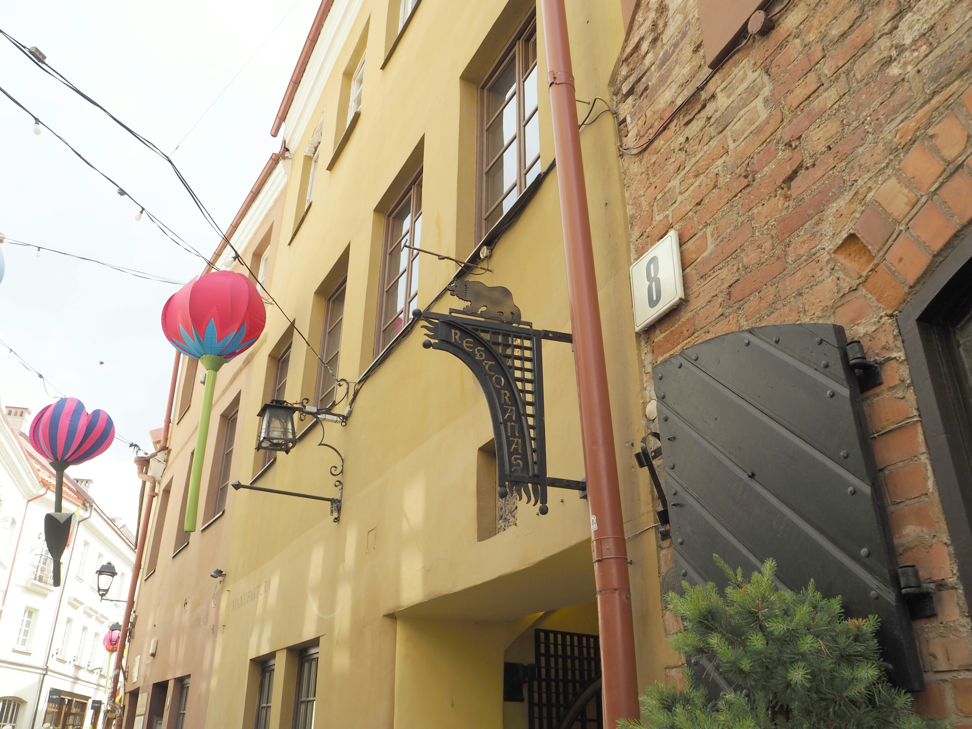 Exterior de un edificio adornado con farolillos coloridos forja decorativa y ventanas