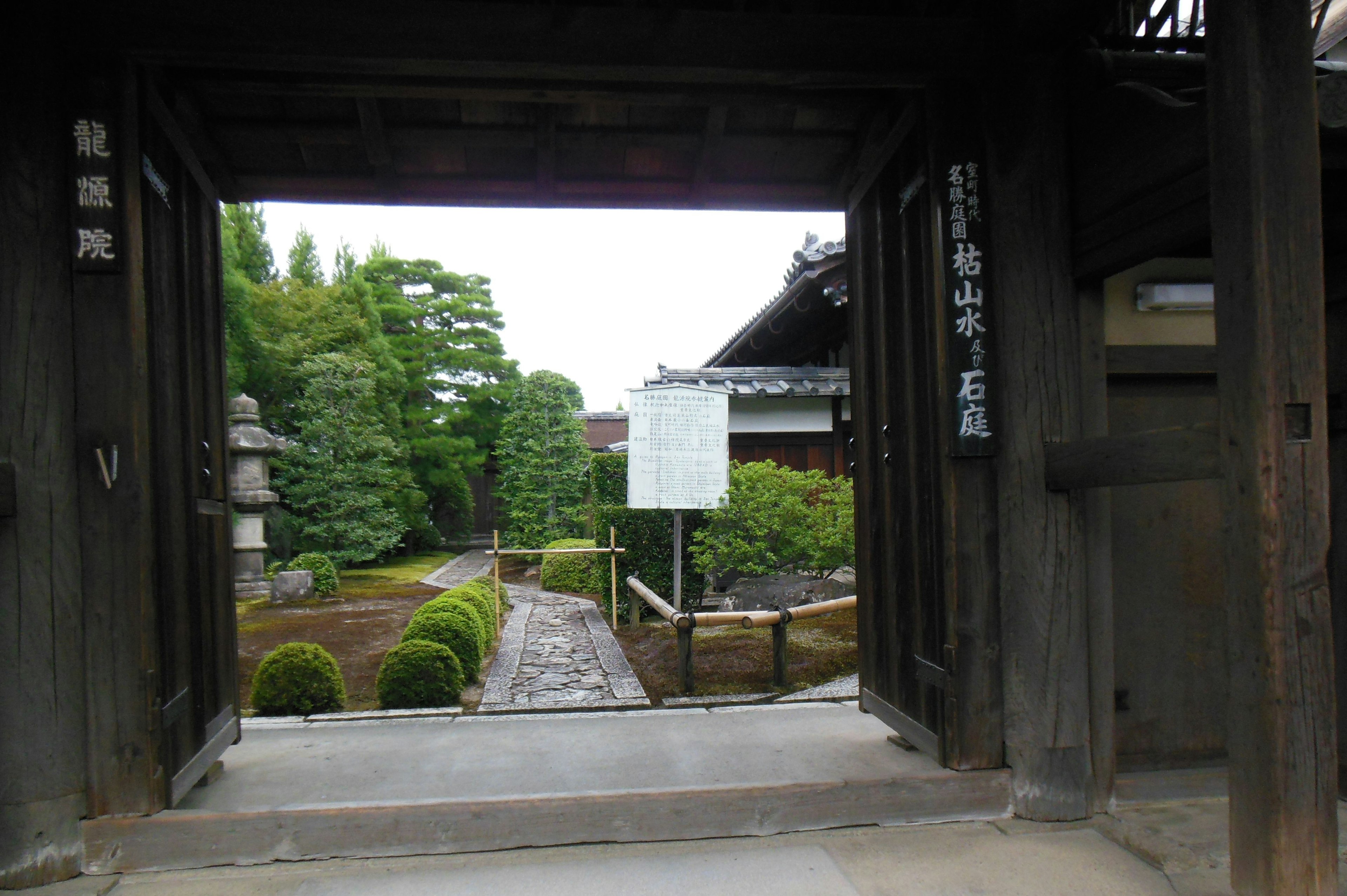 Aussicht durch ein traditionelles japanisches Tor, das einen ruhigen Garten zeigt