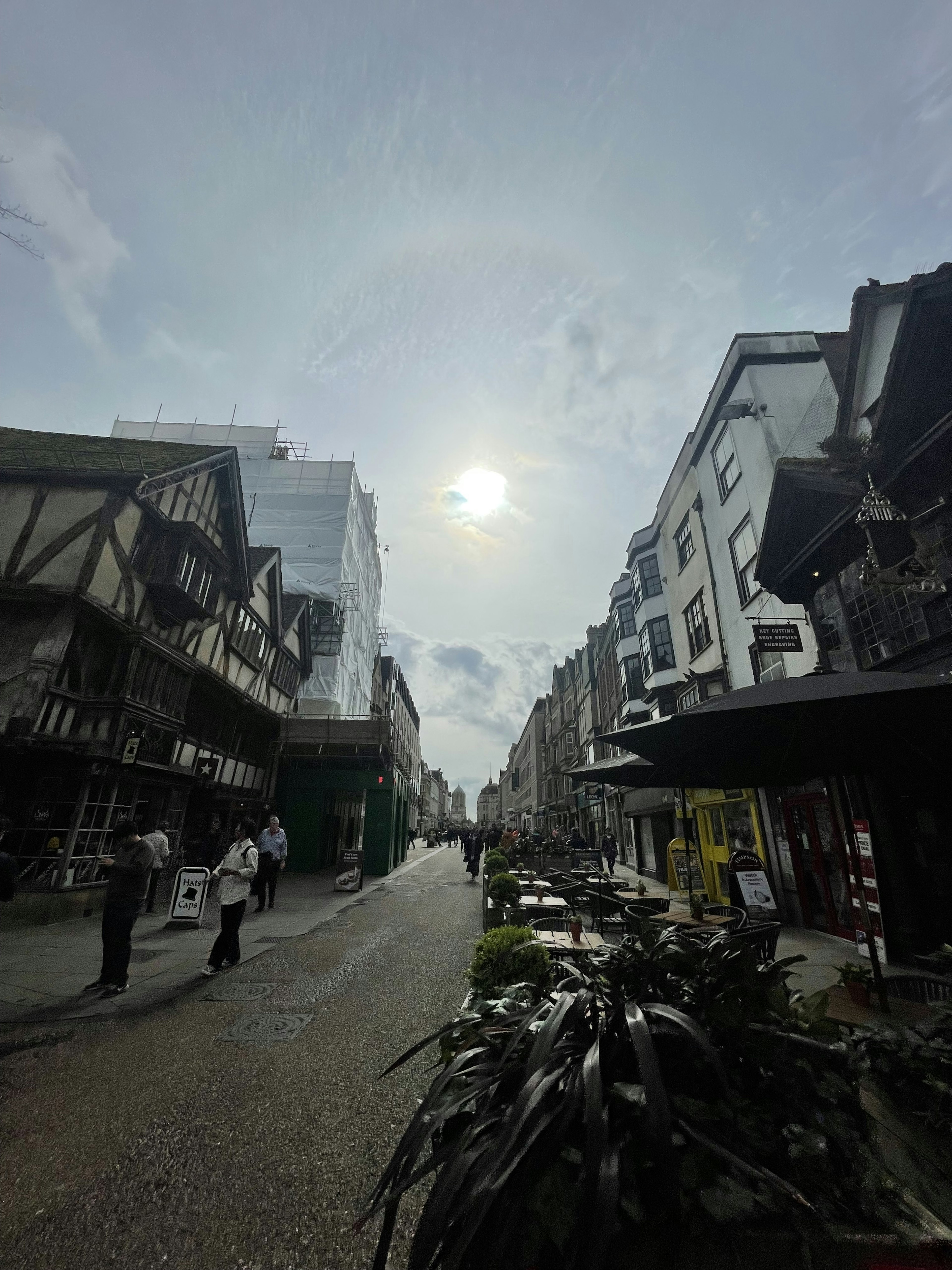 Una scena di strada affollata in una giornata di sole con persone che camminano