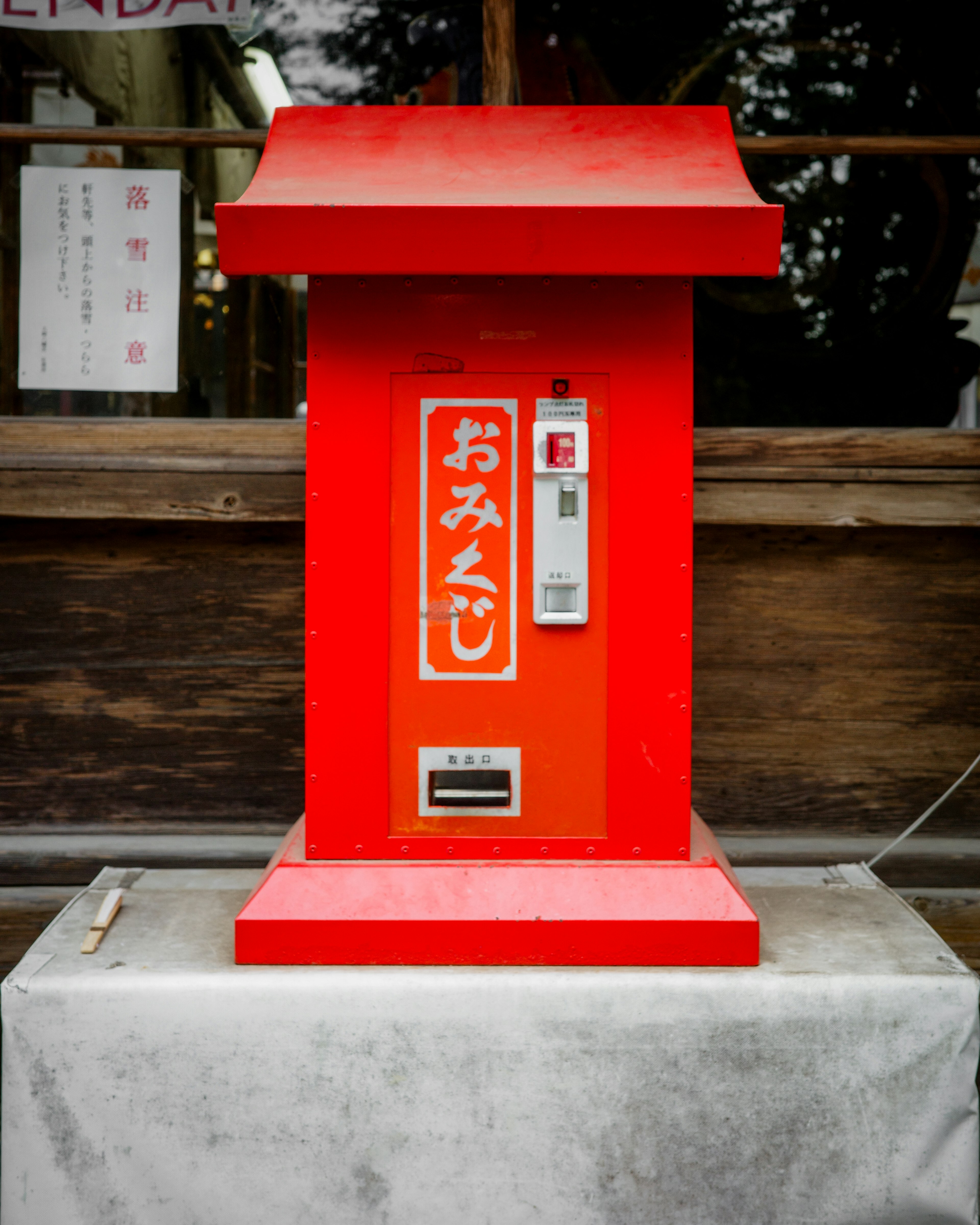 Boîte d'omikuji rouge placée devant un sanctuaire