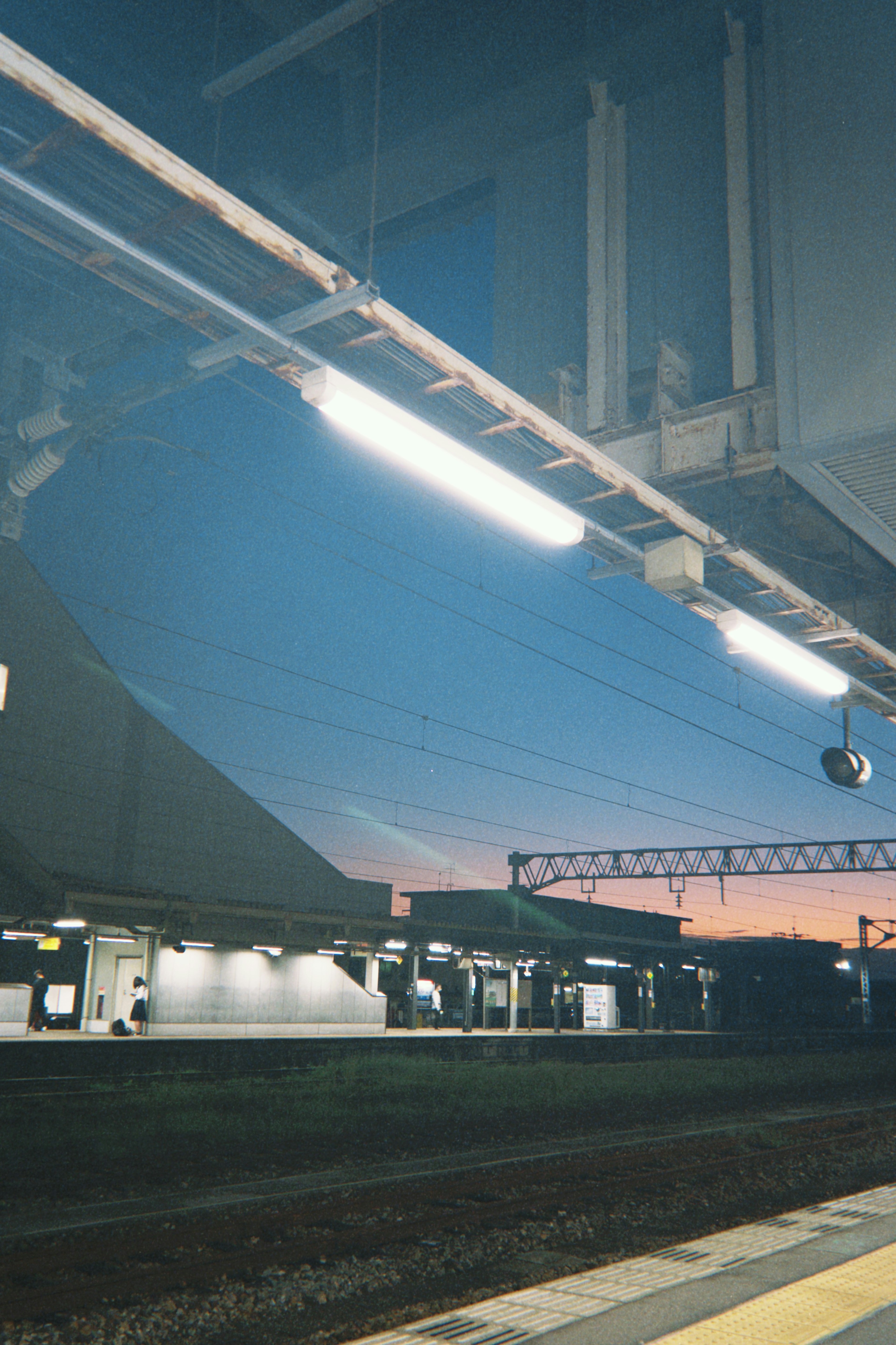 Evening view of a train station platform lights turning on