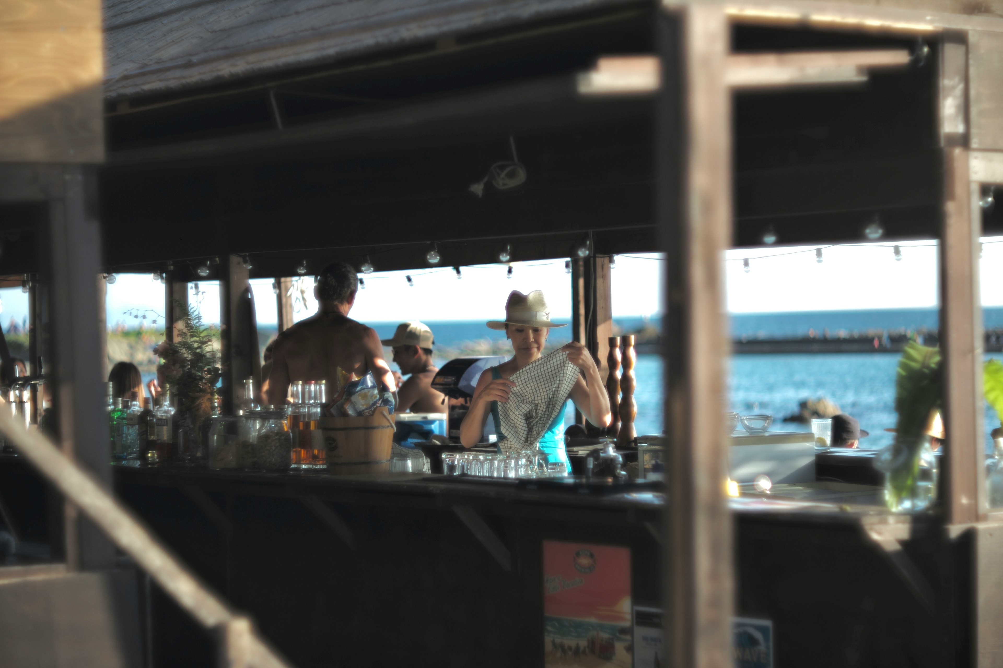 People enjoying drinks at a bar with a view of the sea