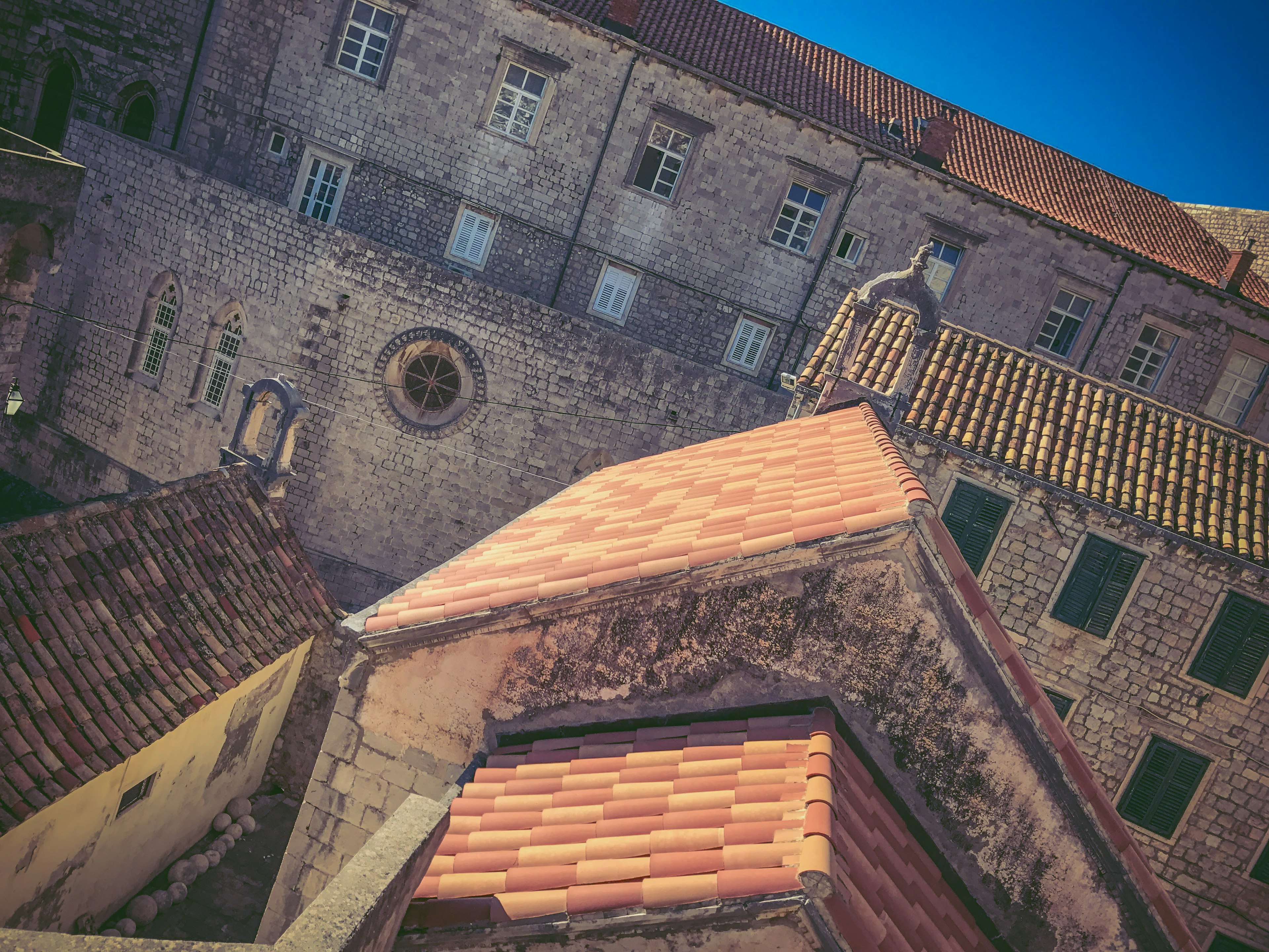 Vue de vieux bâtiments en pierre avec des toits rouges