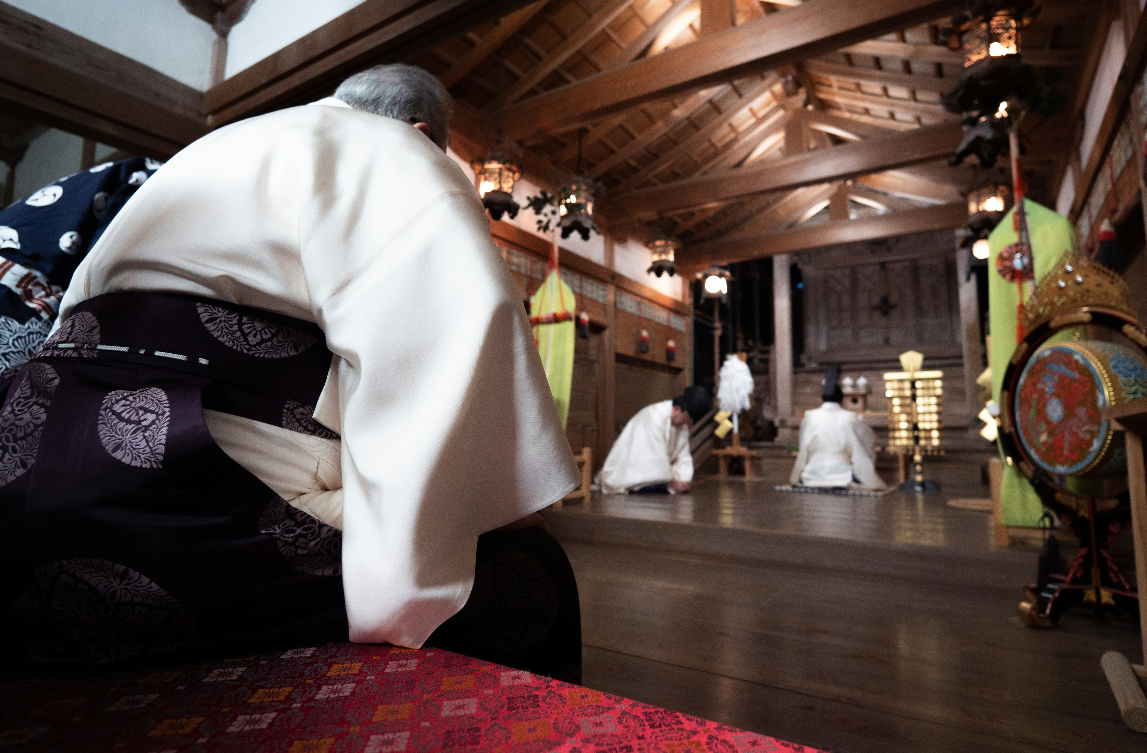 伝統的な服装を着た人々が神社で礼拝している様子