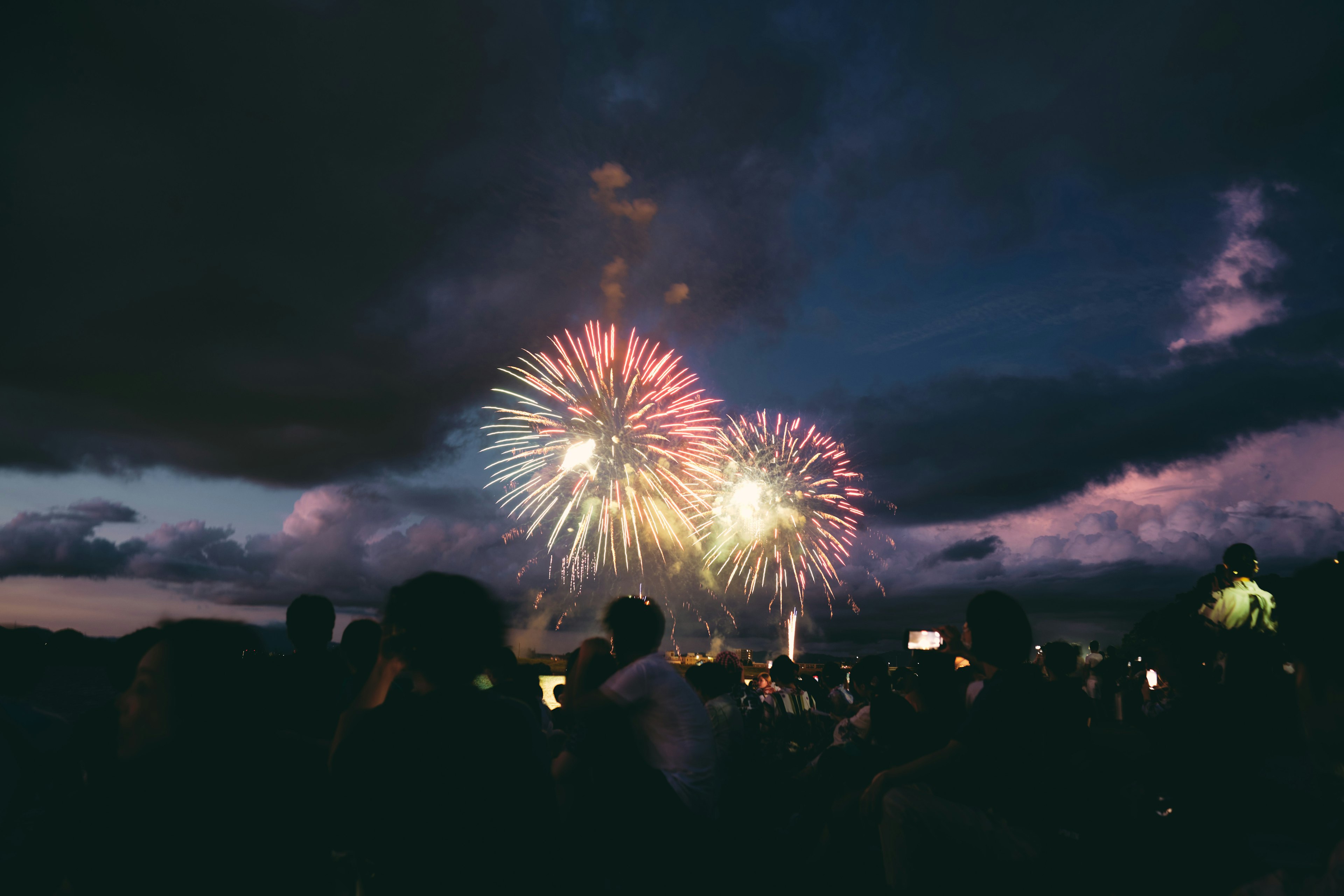 Menschenmenge genießt Feuerwerk, das den Nachthimmel erleuchtet