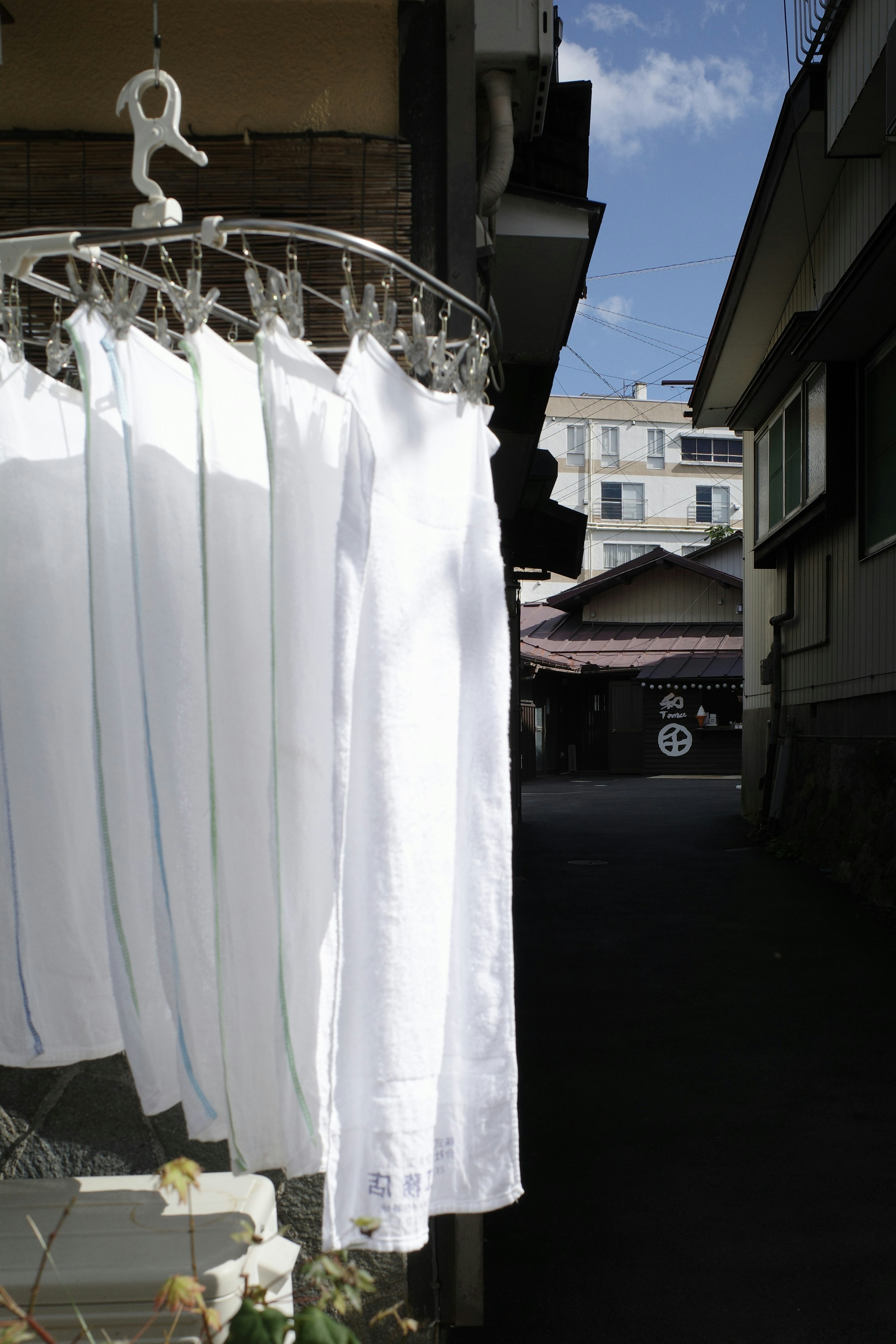 White laundry hanging in a narrow alley