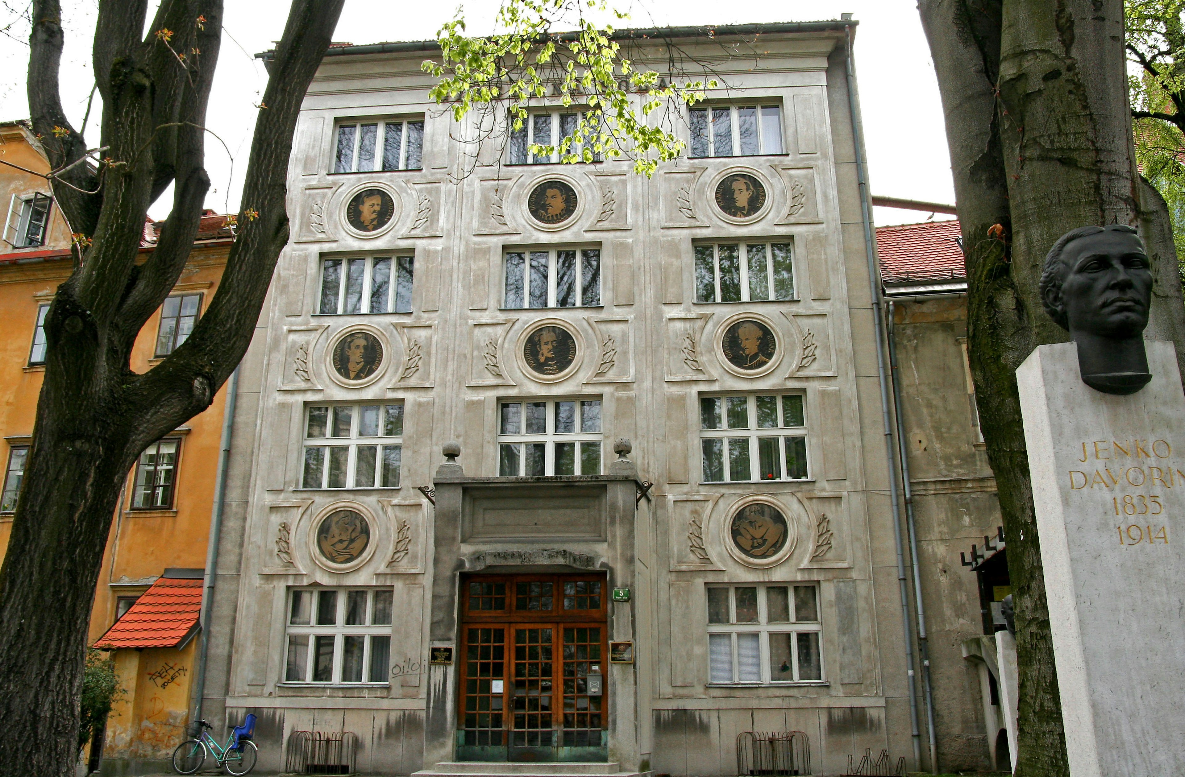 Façade d'un bâtiment avec des éléments décoratifs uniques entouré d'arbres