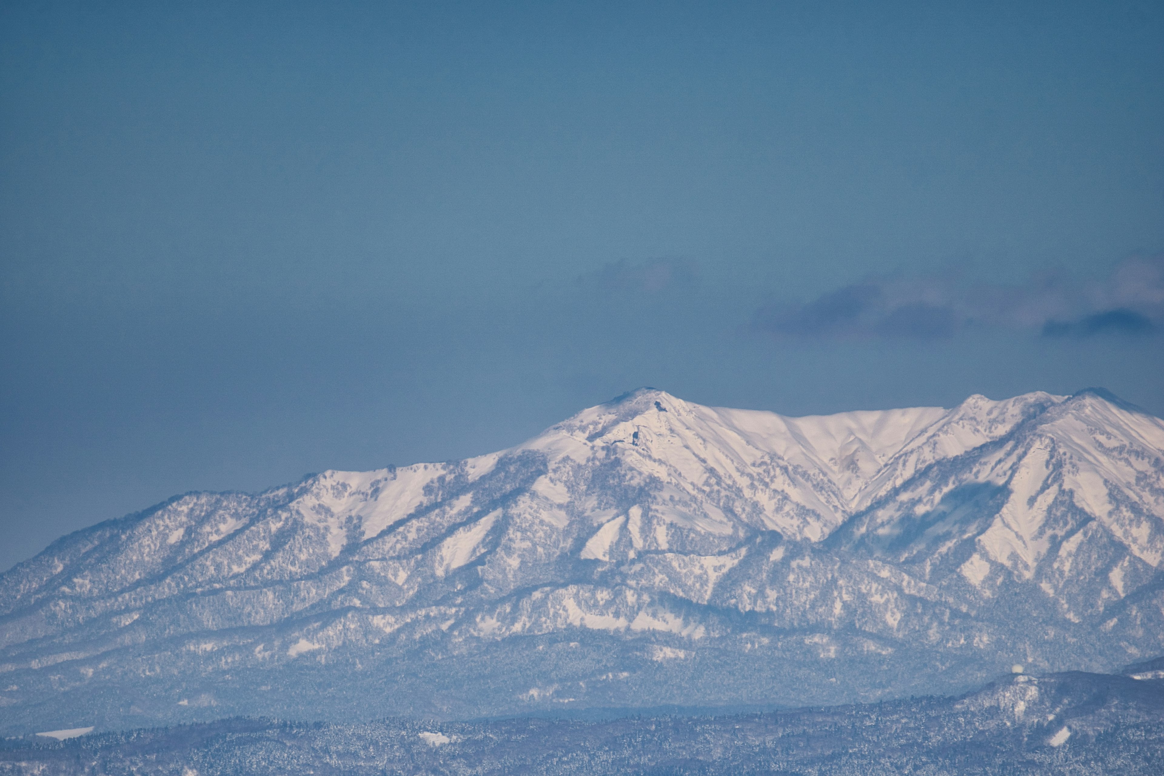 Snow-covered mountains under a blue sky