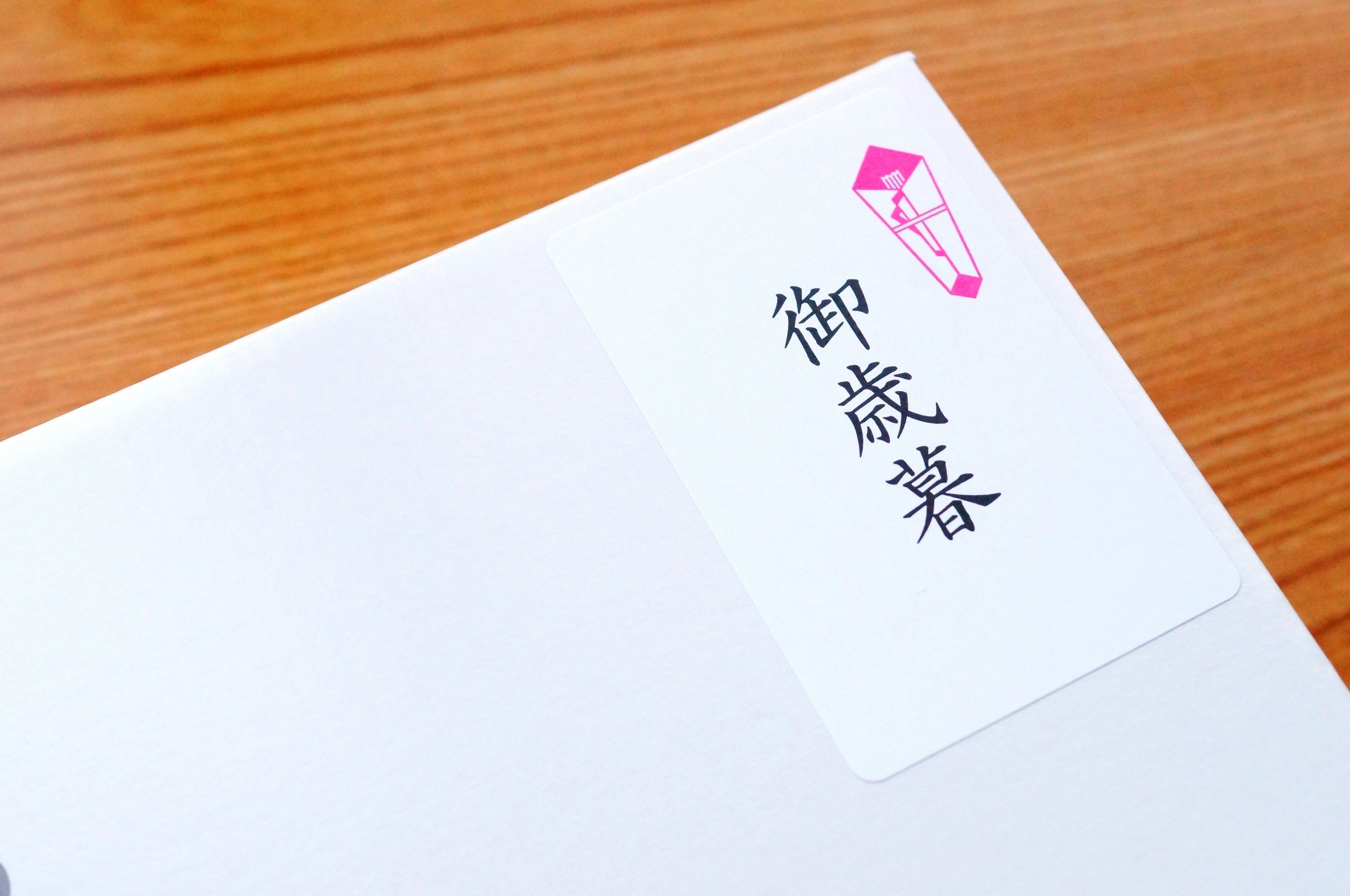 White envelope with a pink seal and black characters label