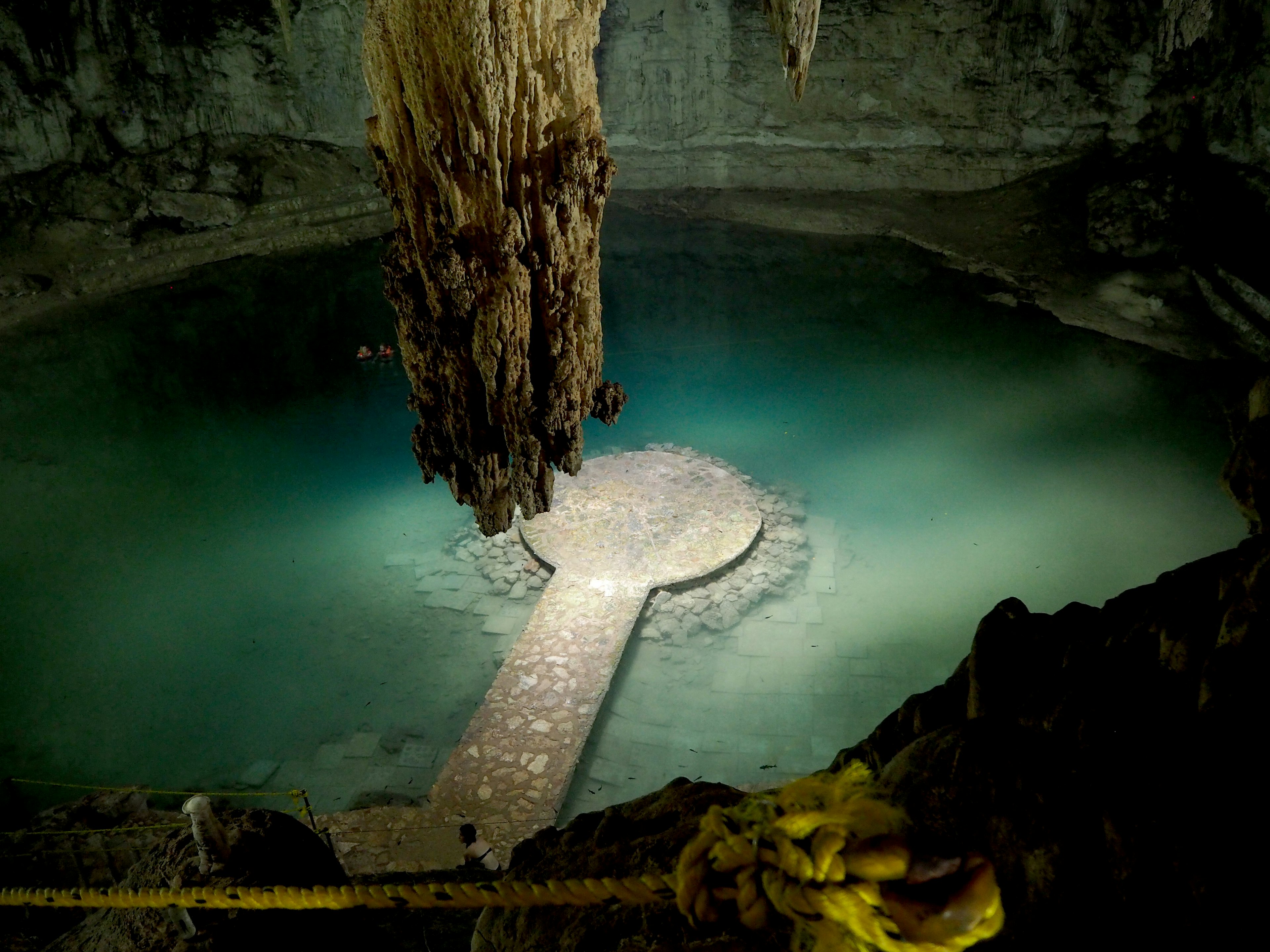 Cave view with a water pool and limestone stalactites