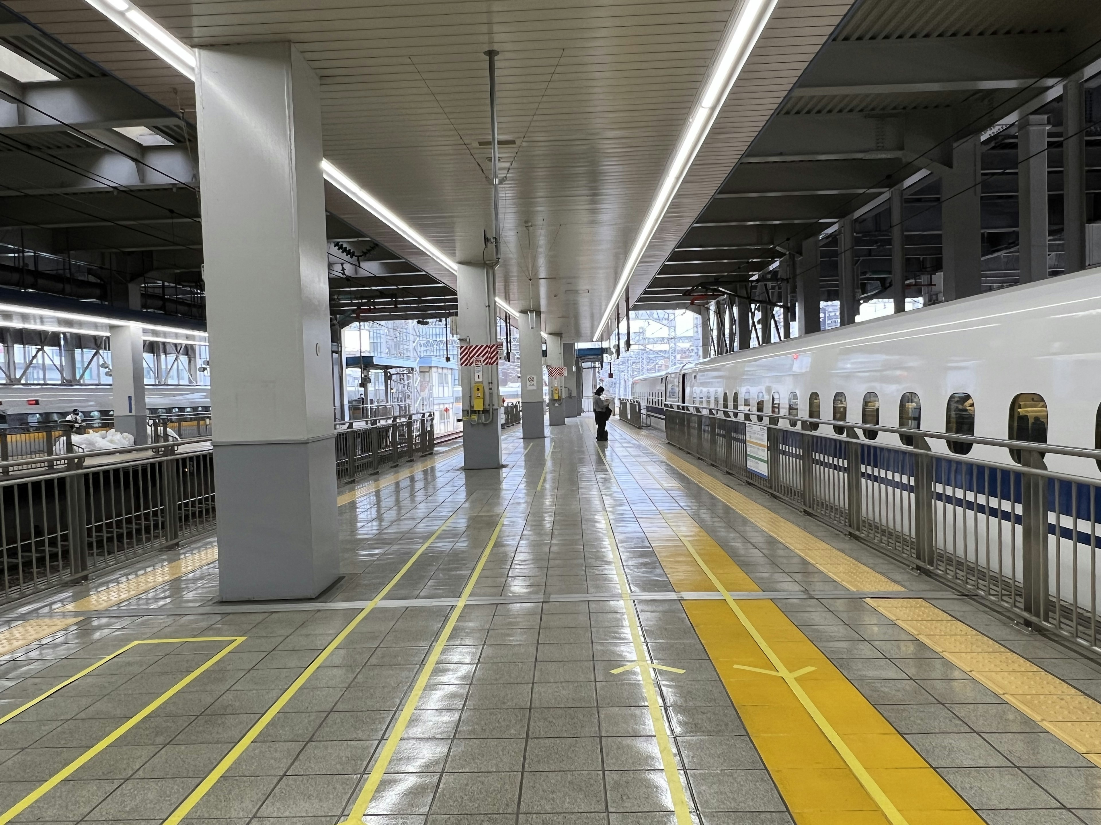 Innenansicht einer Shinkansen-Bahnhof-Plattform mit einer gehenden Person