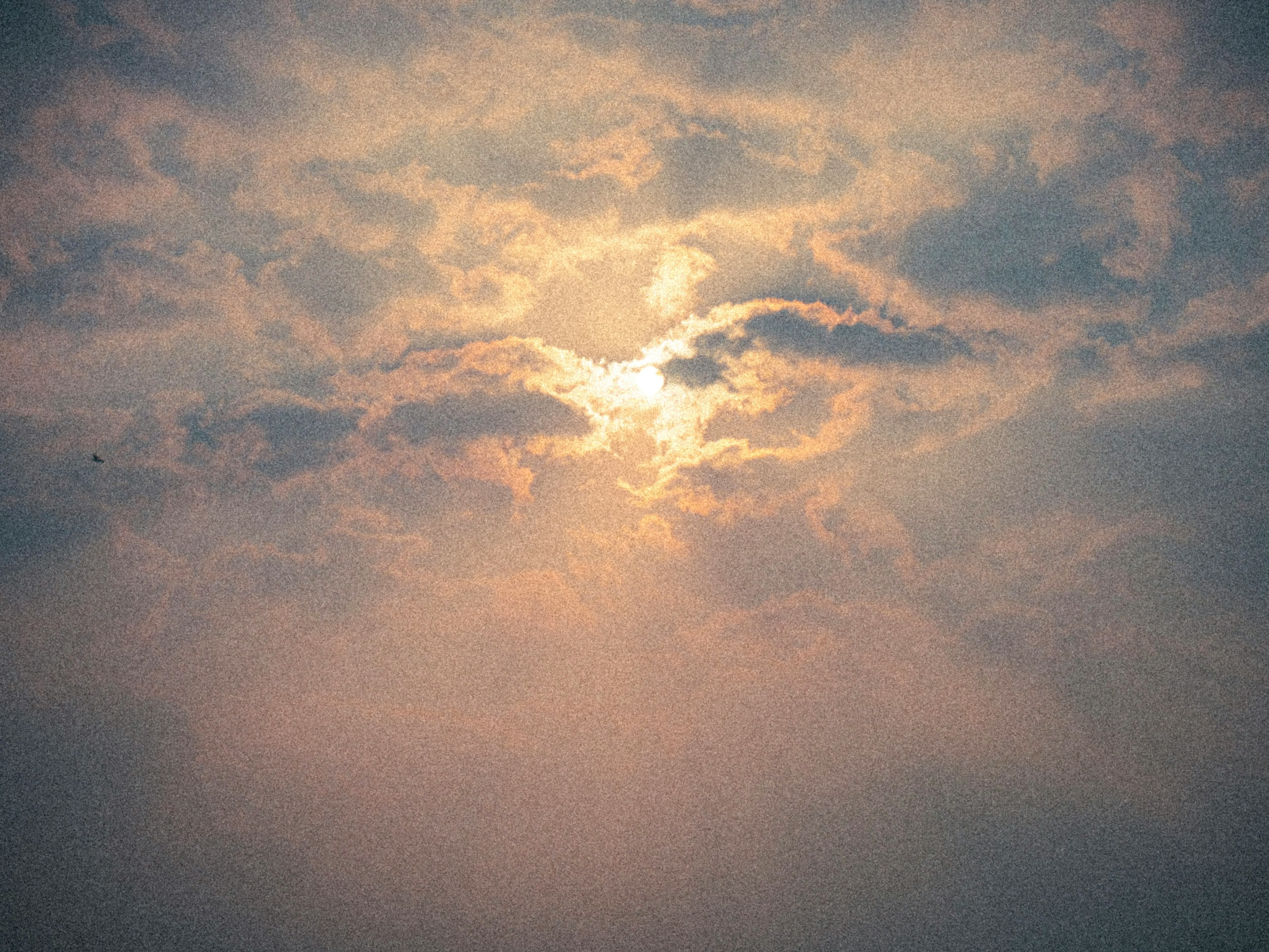 曇り空に差し込む光が雲を照らす美しい風景